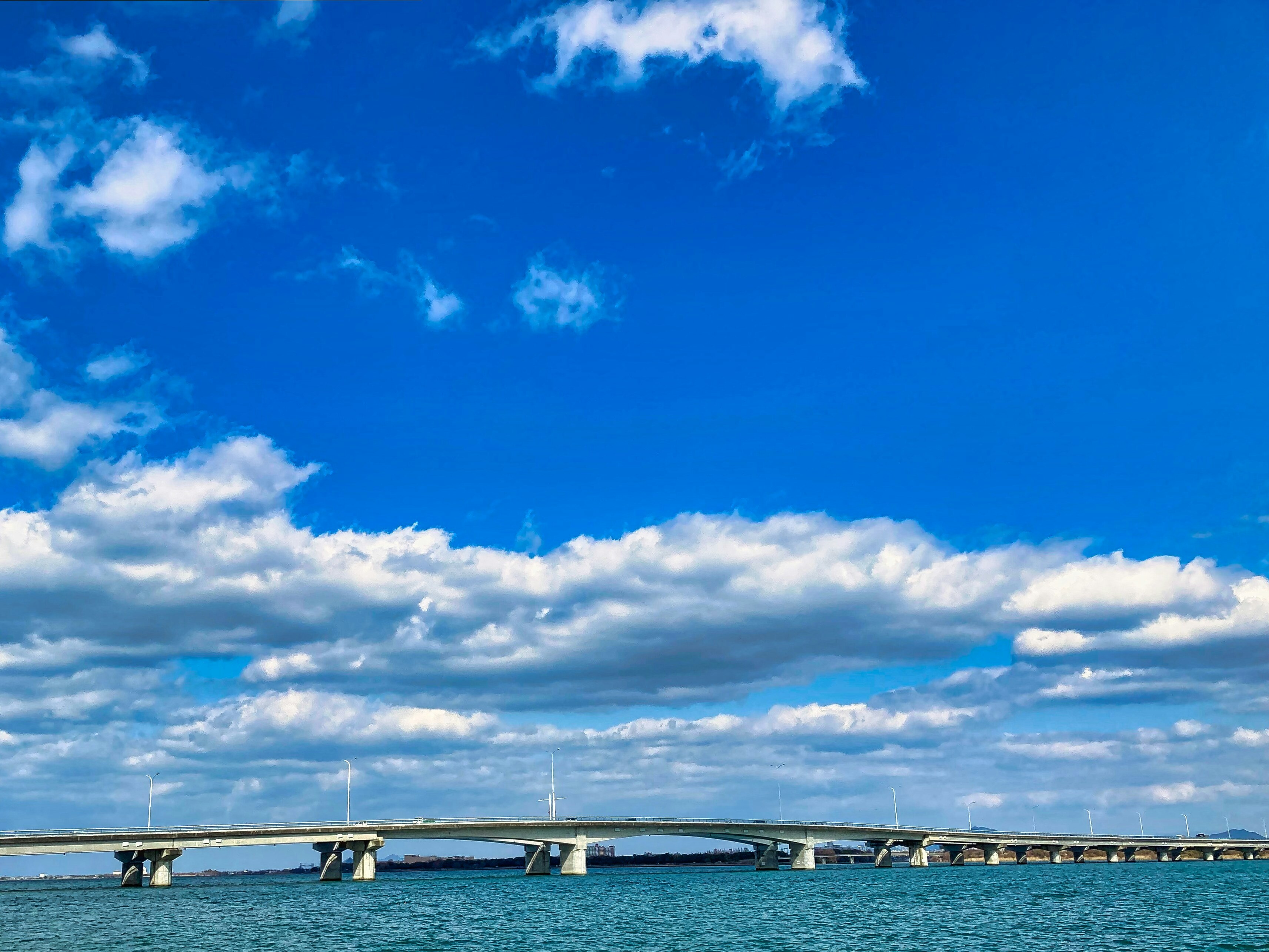 青空の下を走る橋と海の広がり