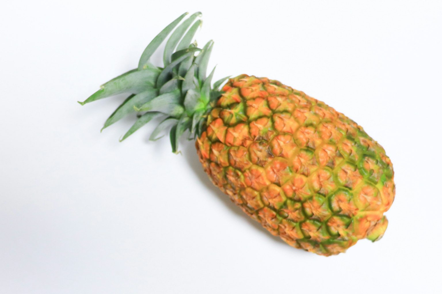 Una piña naranja vibrante colocada sobre un fondo blanco