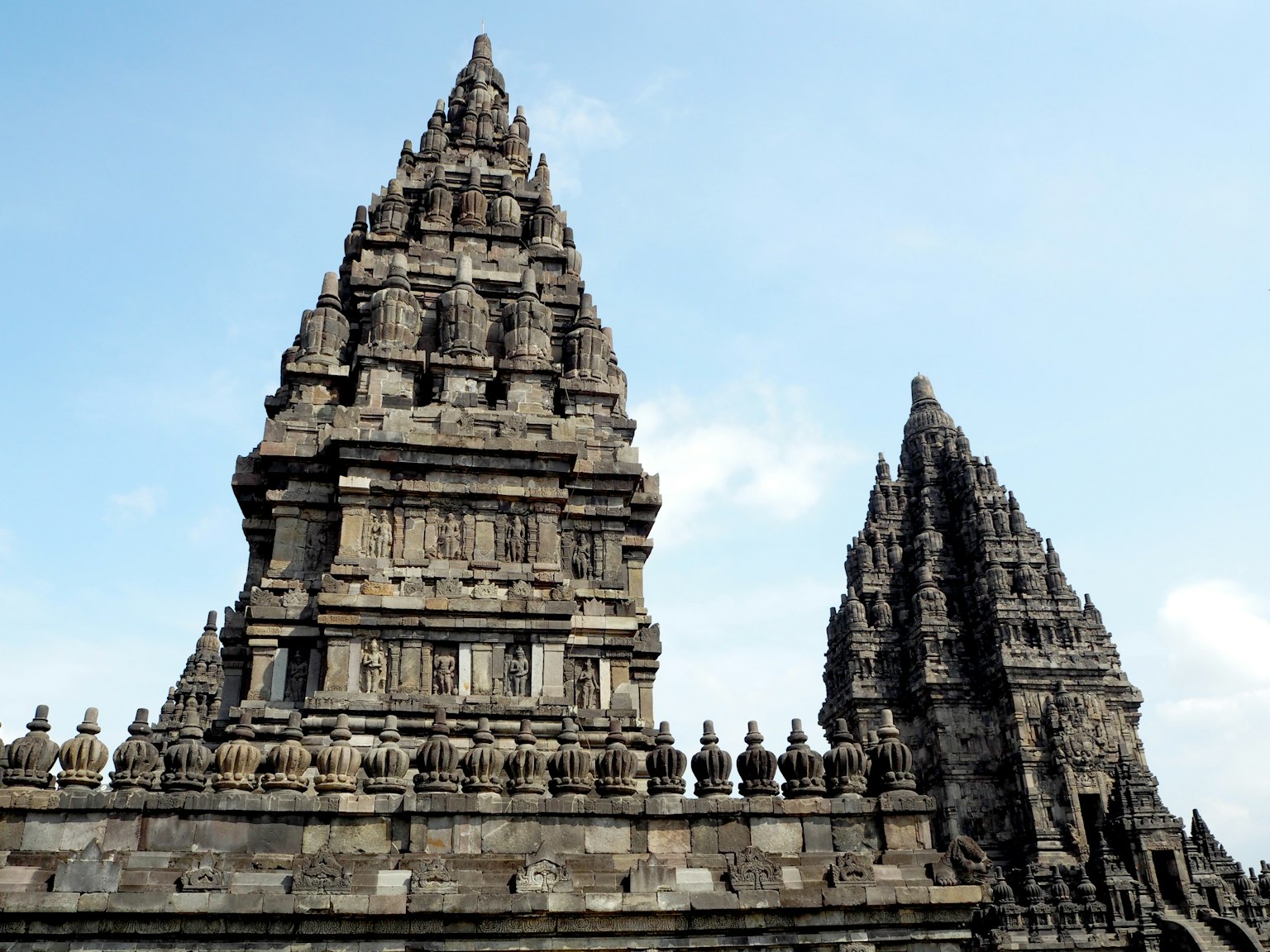 Complesso del tempio di Prambanan con torri di pietra contro un cielo blu