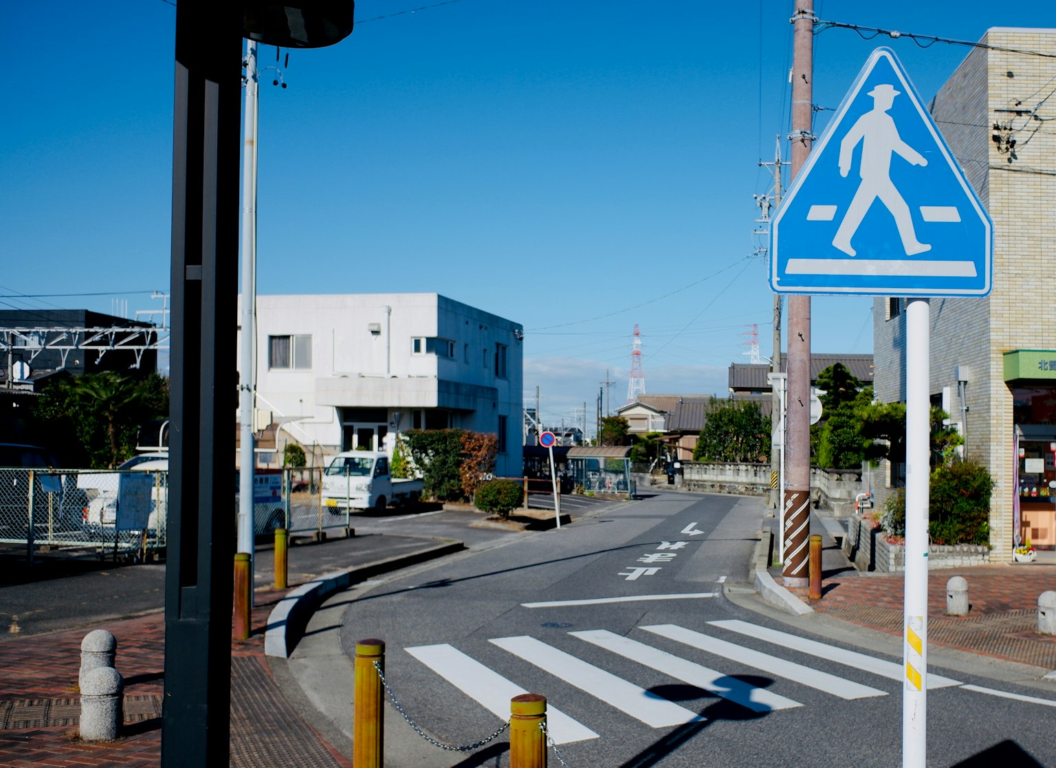 Ruhige Straßenansicht mit blauem Fußgängersignal und Zebrastreifen