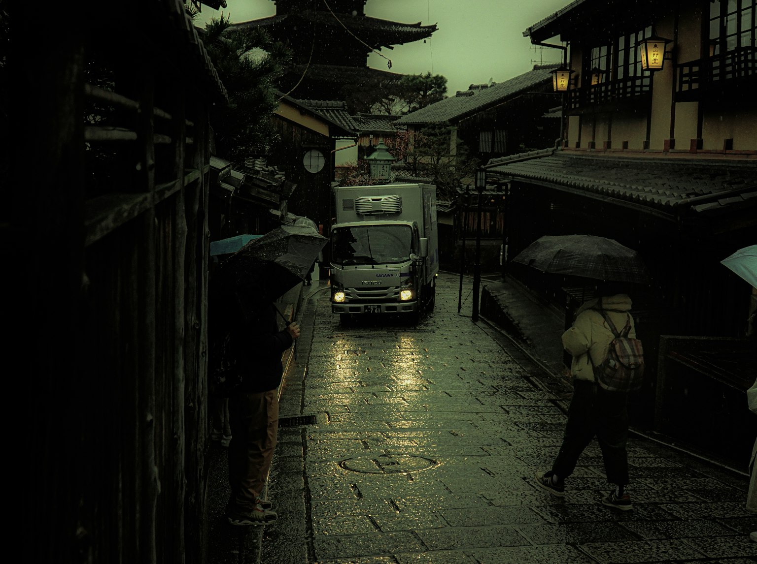 雨の中の街並みと車両が見える風景