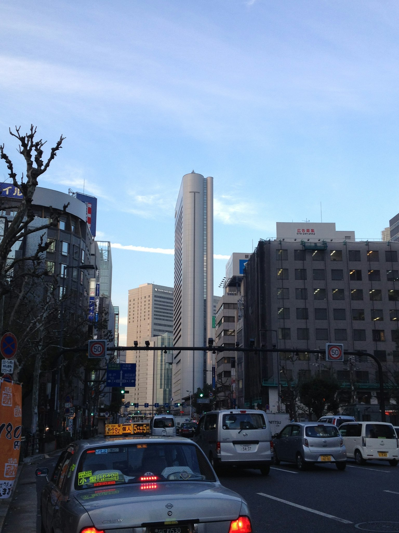 城市風景高樓大廈繁忙的街道汽車藍天和雲朵