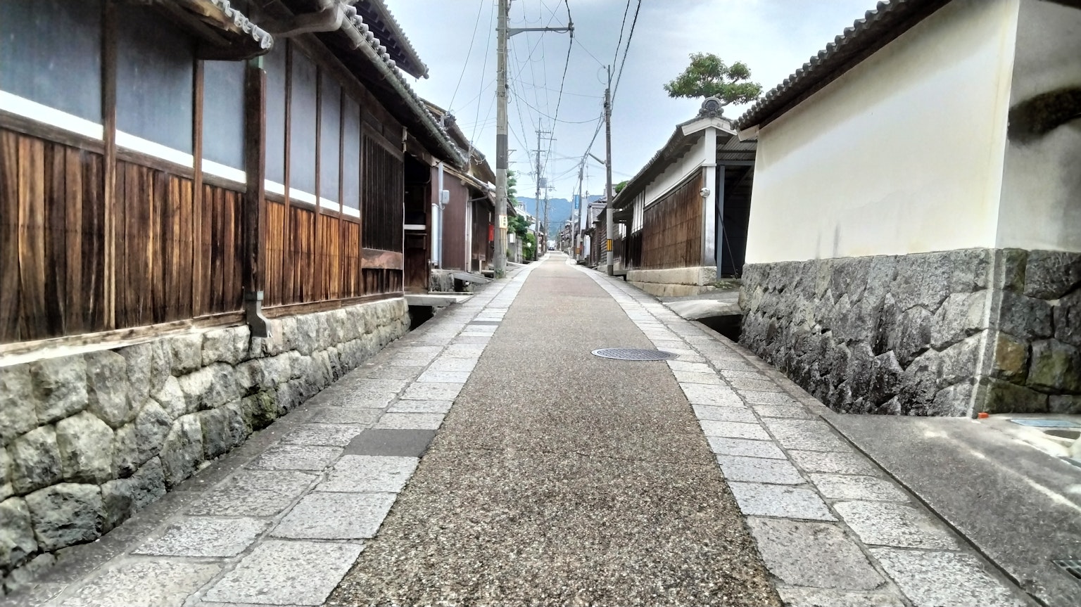 Narrow stone-paved path lined with traditional wooden houses