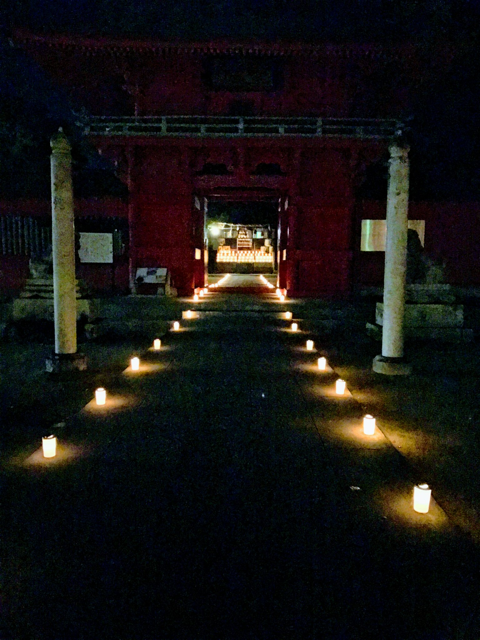 夜晚通往紅色神社門的蠟燭排成的道路