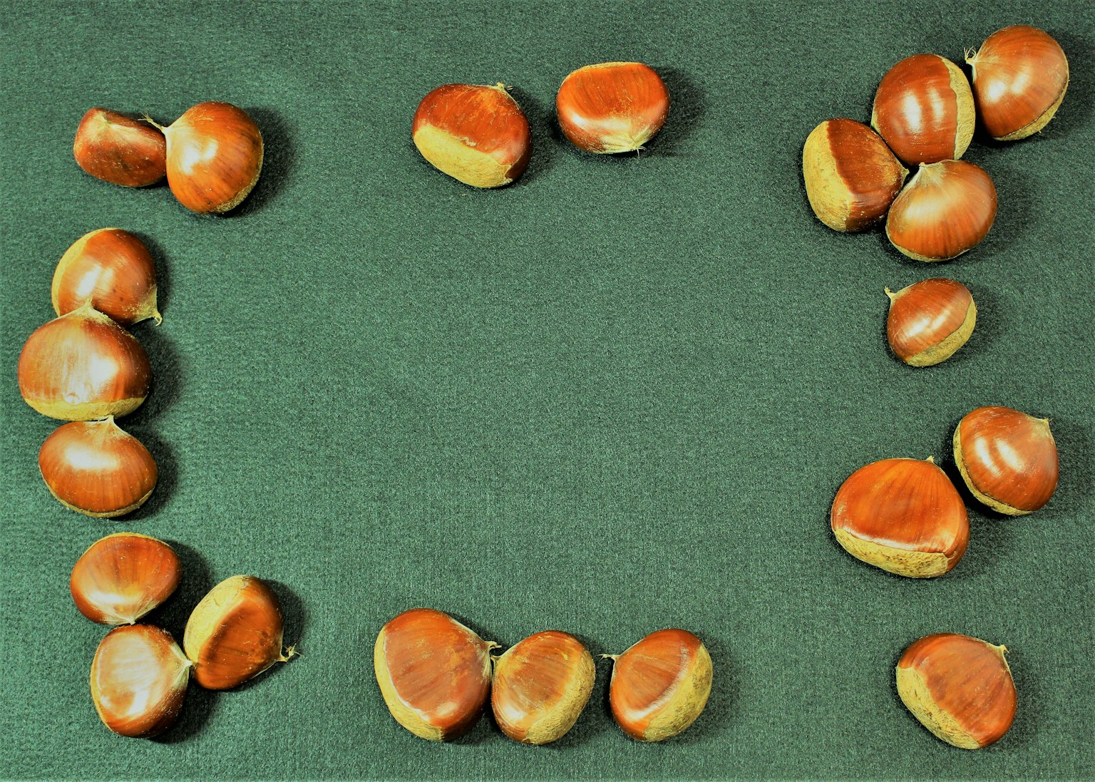 Castagne disposte su un tessuto verde