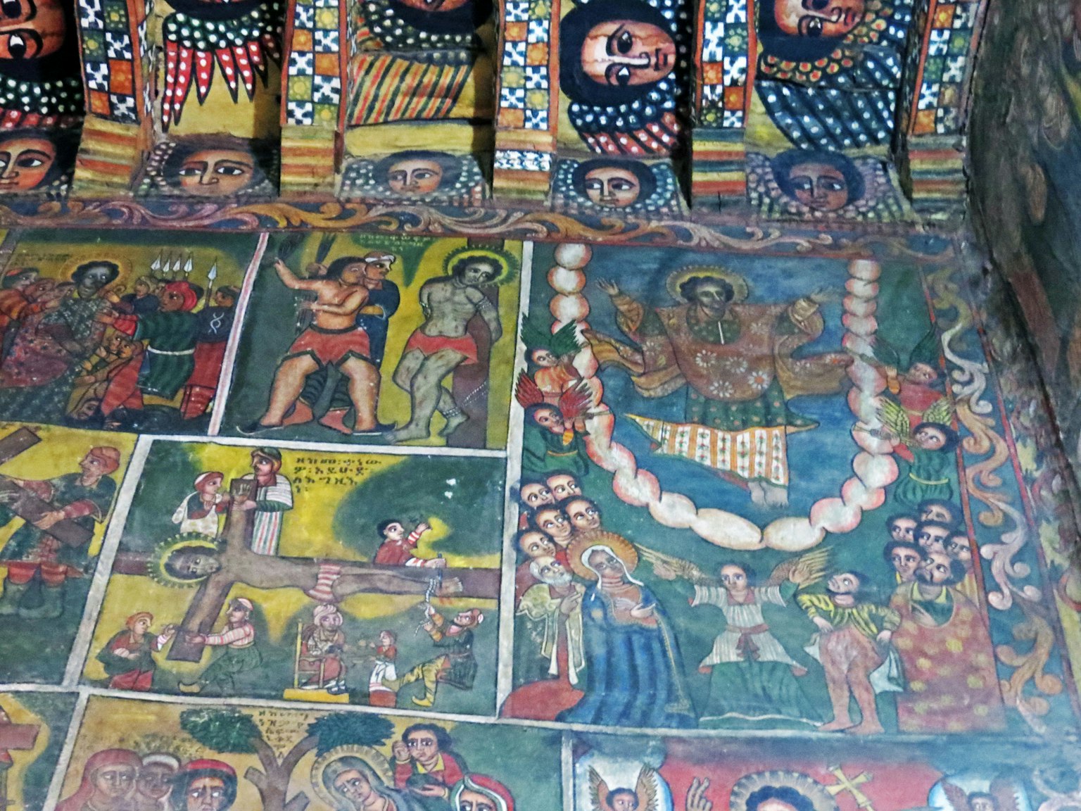 Interno di una chiesa storica con affreschi religiosi colorati sul soffitto e sulle pareti