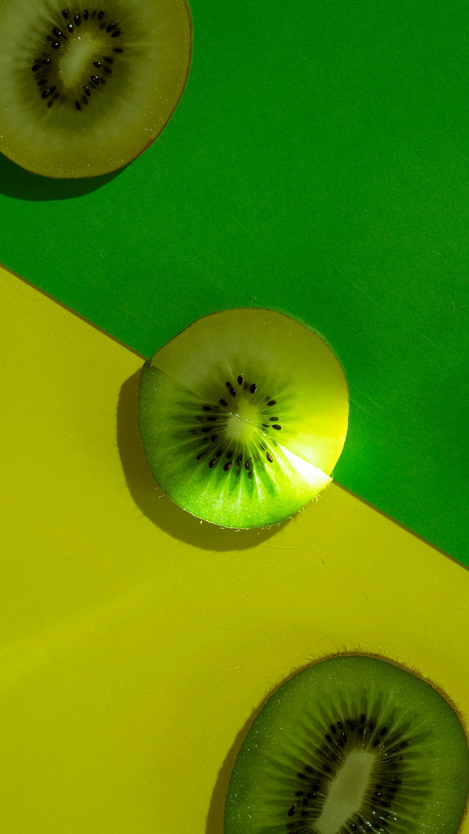 กีวีหั่นแว่นบนพื้นหลังสีเขียวและสีเหลืองสดใส