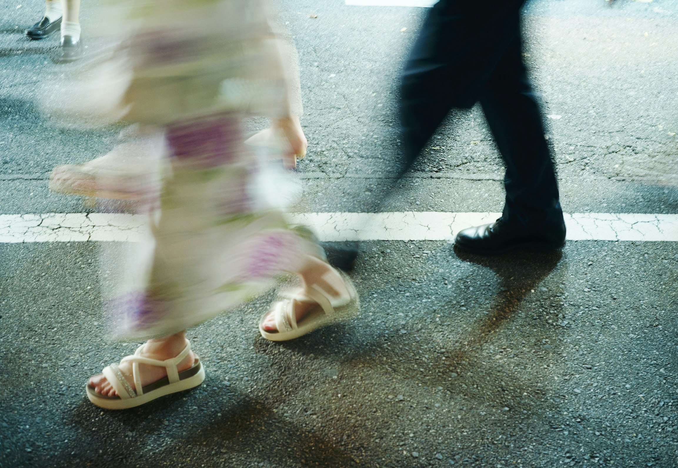 夏の路上を歩く子どものサンダル