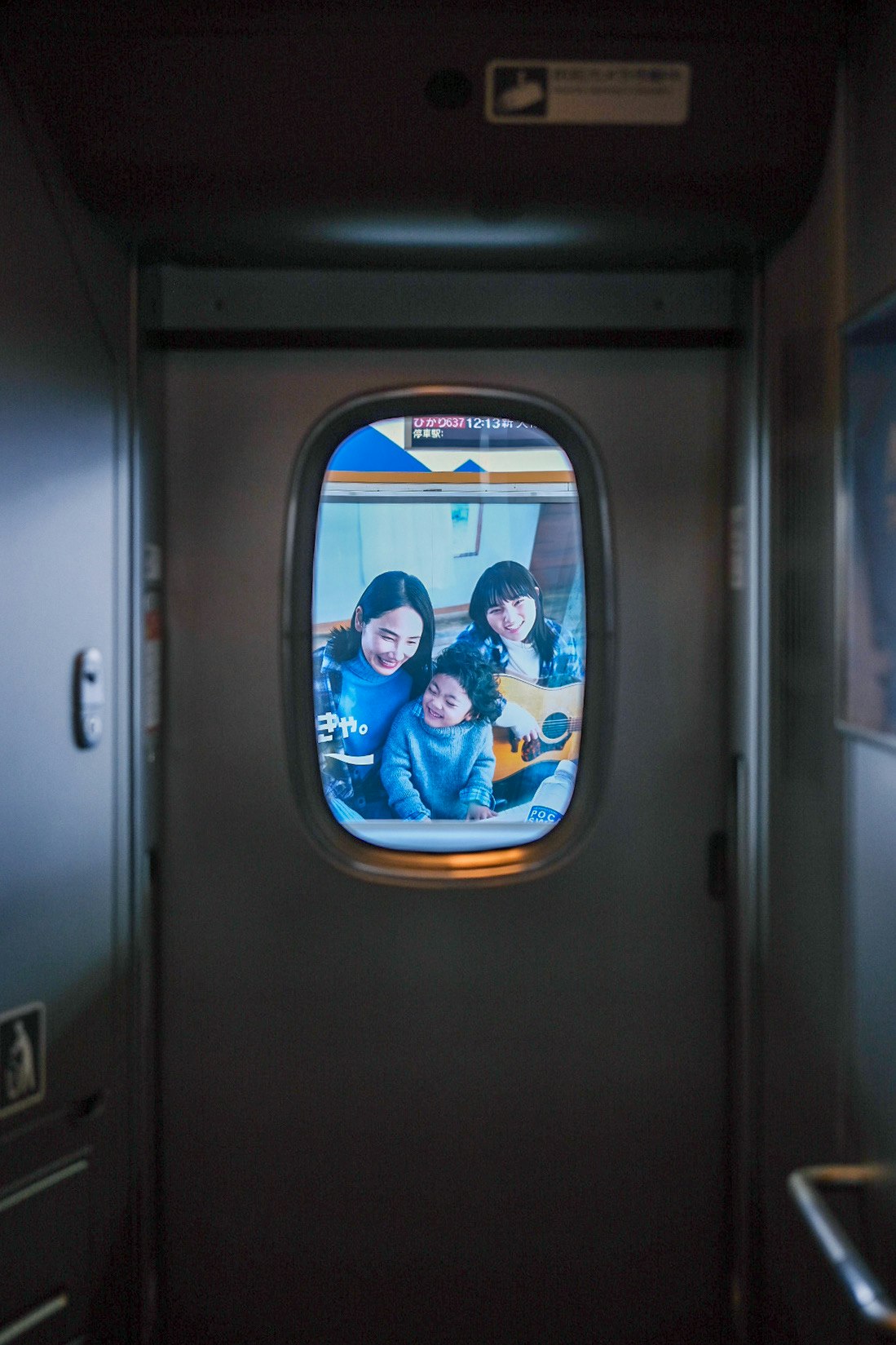 新幹線の小窓から見える車内の家族写真
