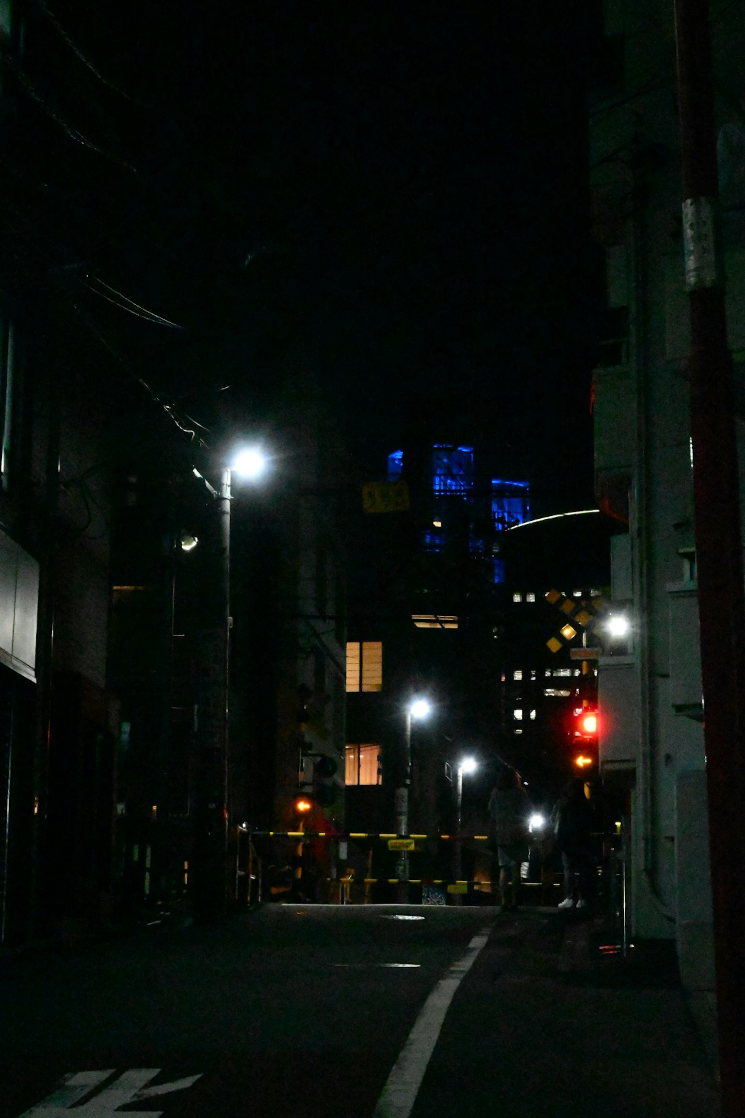 夜晚安静的街道，街灯和远处蓝色灯光的建筑