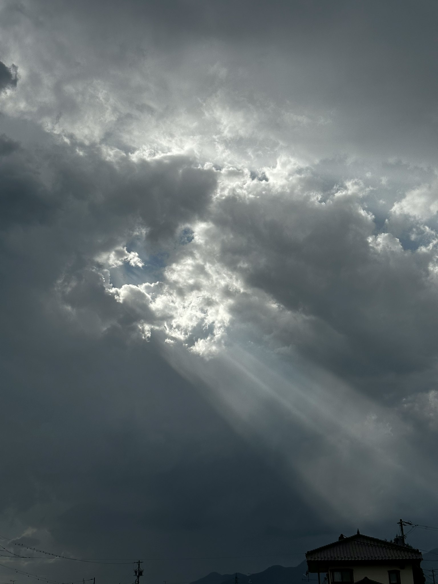 Luce che filtra attraverso nuvole scure con un cielo drammatico