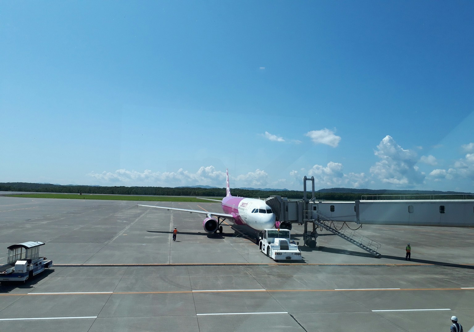 Rosa Flugzeug auf dem Rollfeld mit klarem blauen Himmel geparkt