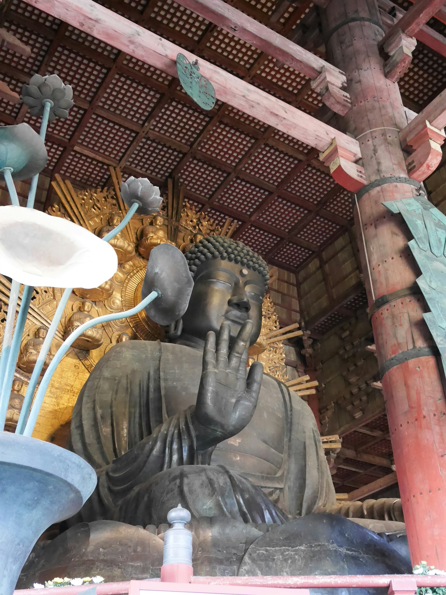 Bức tượng Phật lớn ngồi với tay giơ lên bao quanh bởi các yếu tố trang trí