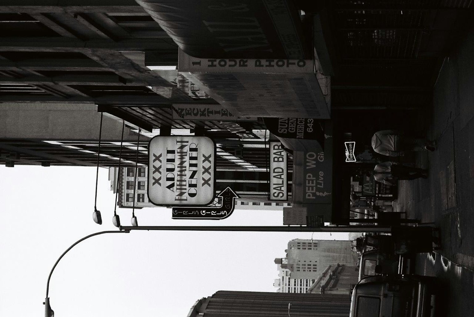 Black and white city street with signs and vehicles