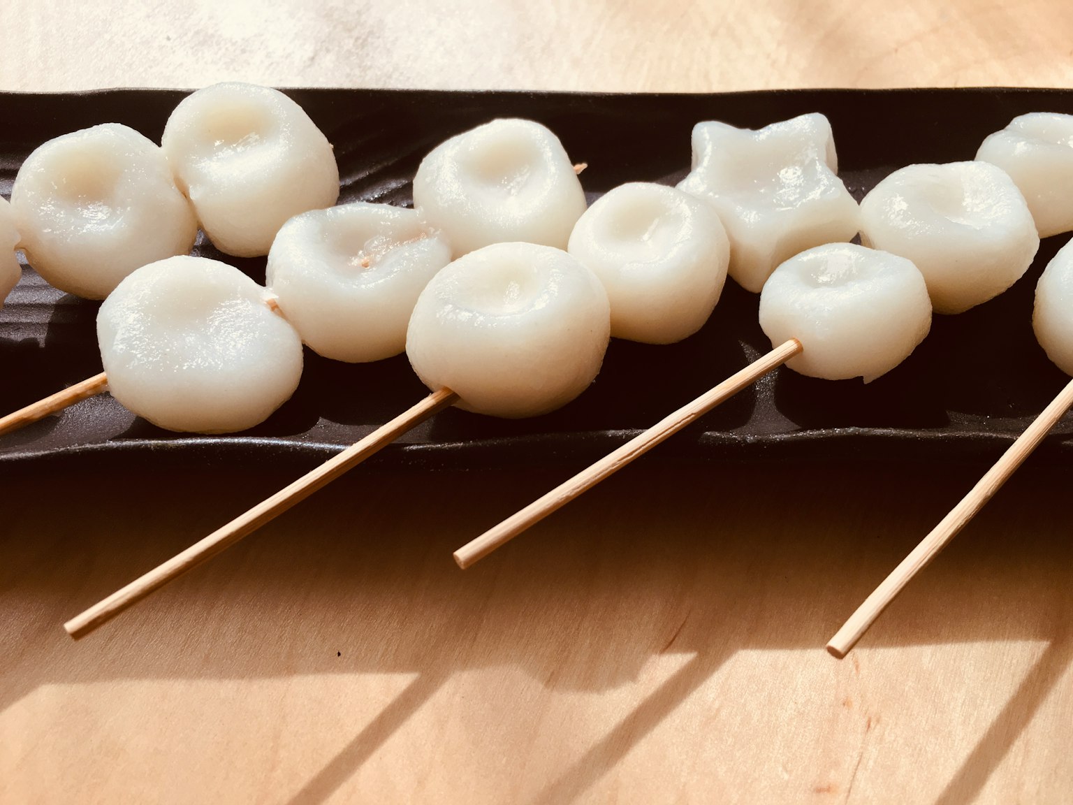 White dumplings on skewers arranged on a plate