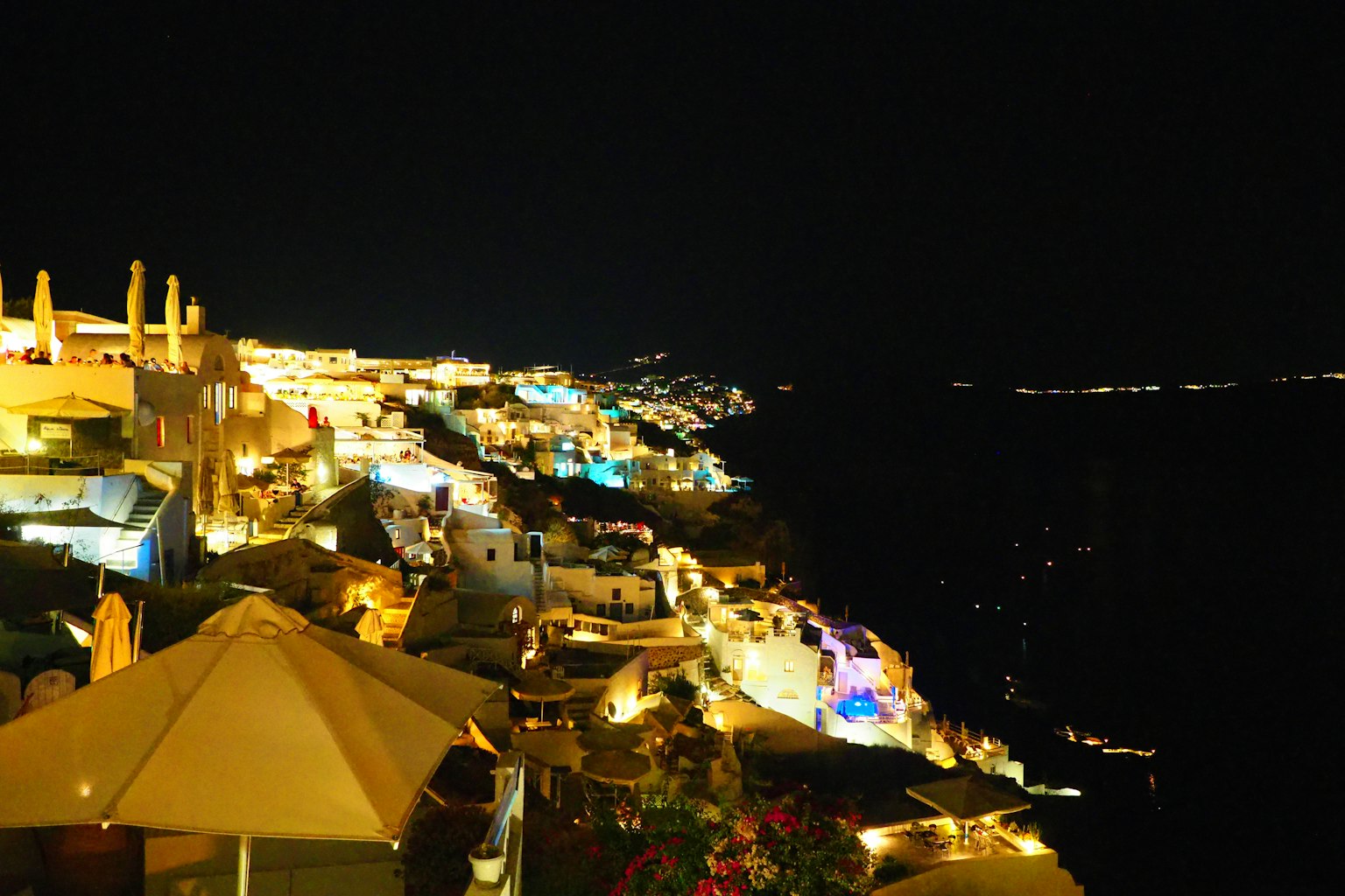 Ánh đèn và các tòa nhà đẹp dọc theo bờ biển Santorini vào ban đêm