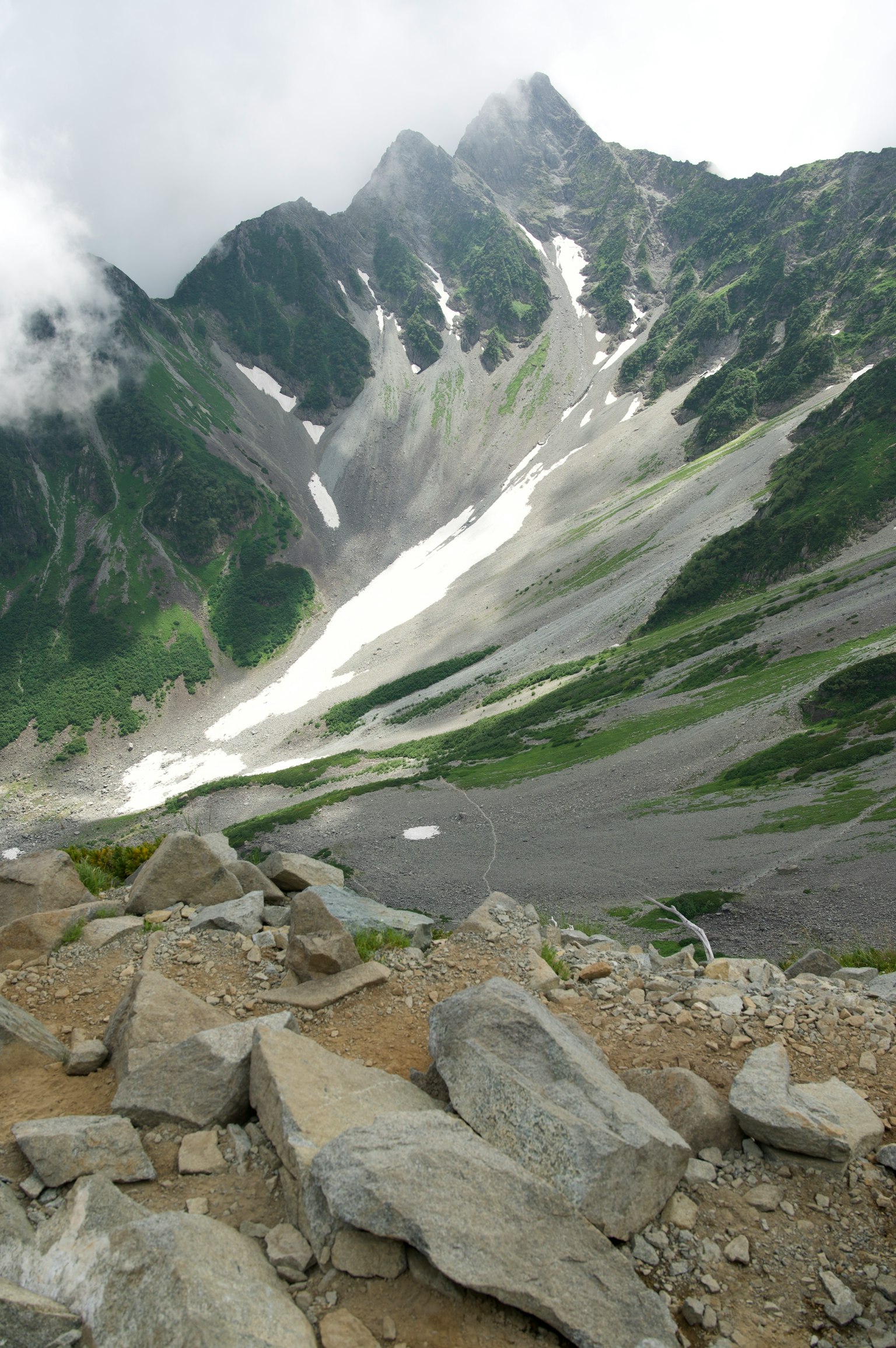 Vue pittoresque de montagnes vertes avec des pentes enneigées
