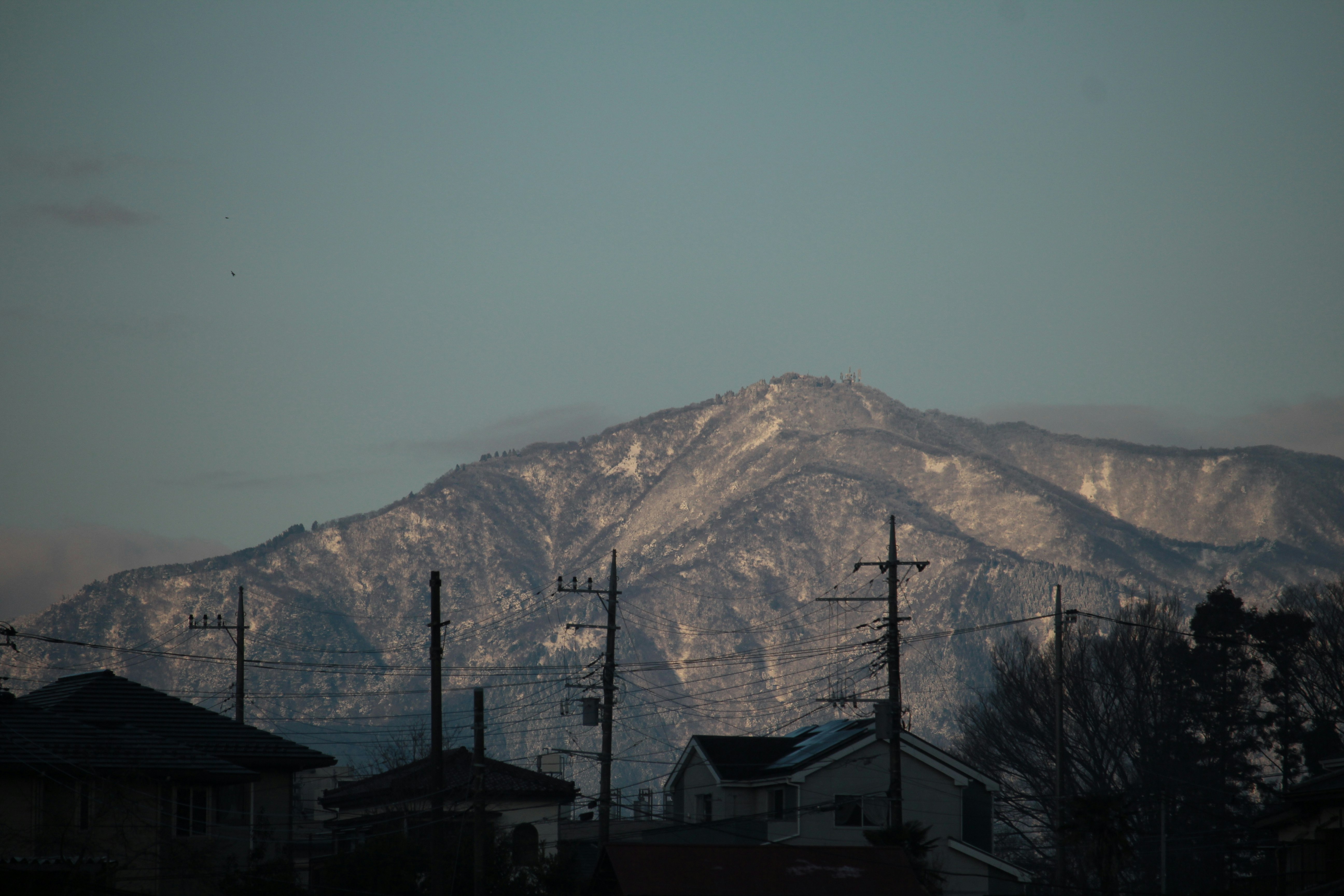 雪の積もる山肌を望む夕暮れの町並み
