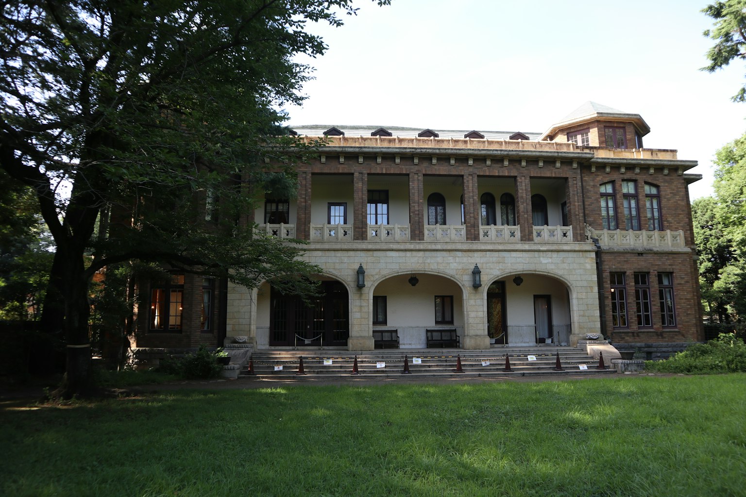 歷史建築外觀，周圍環繞著綠色草坪和樹木，建築風格優美