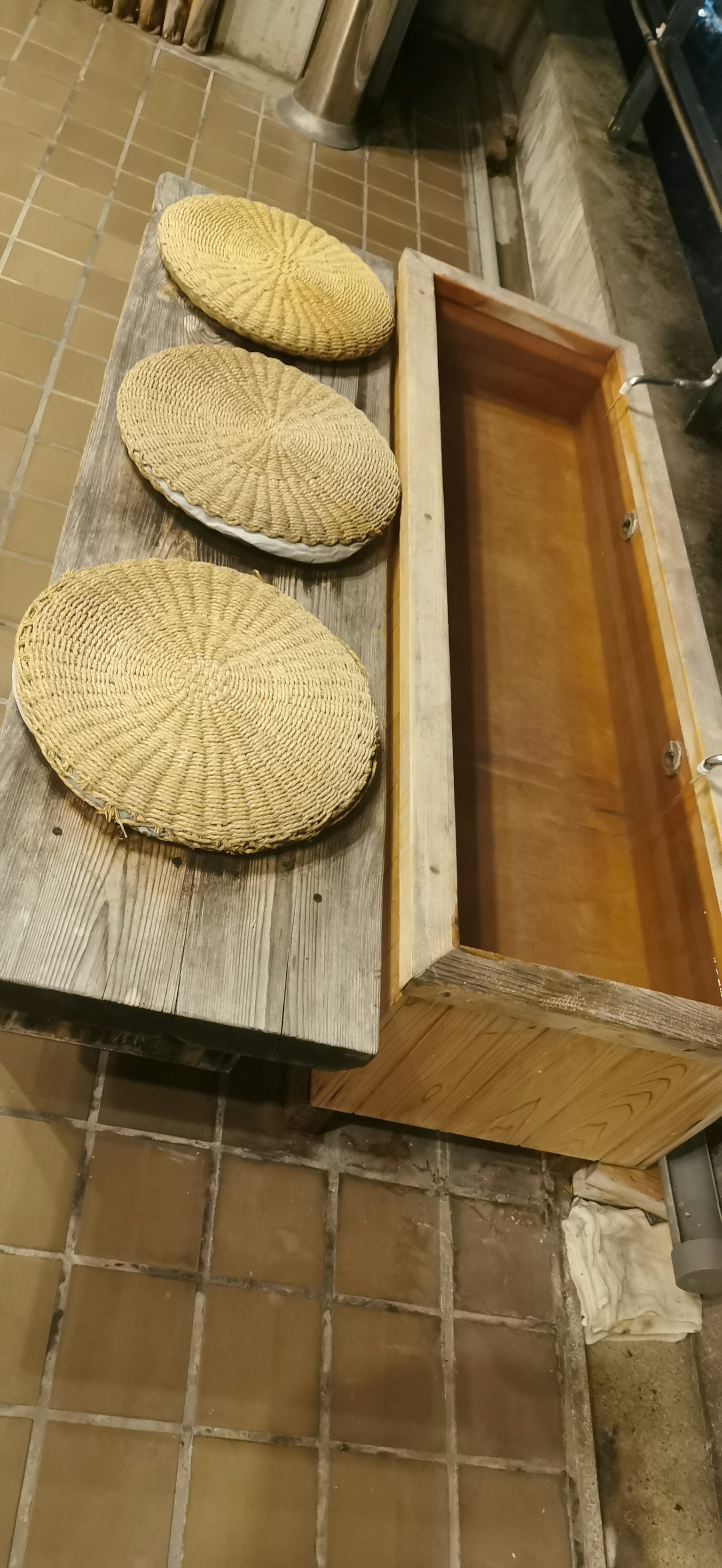Mesa de madera con tres cojines redondos y una caja de madera