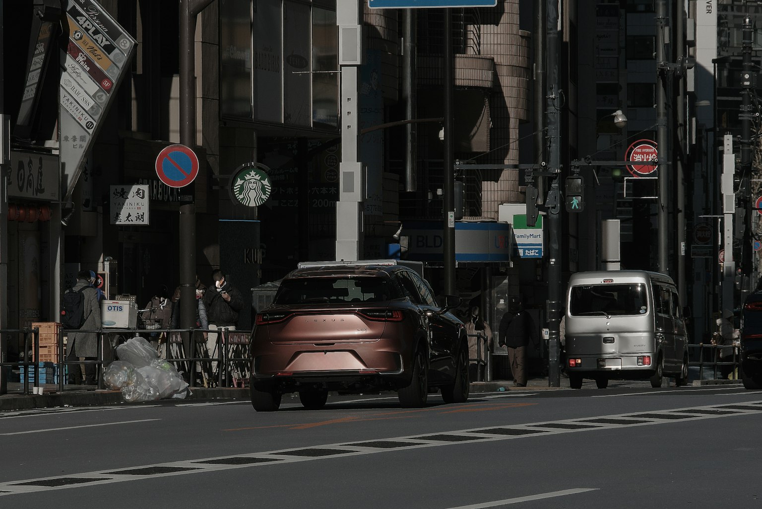 城市街道的景象，有一辆红色汽车和一辆小白车