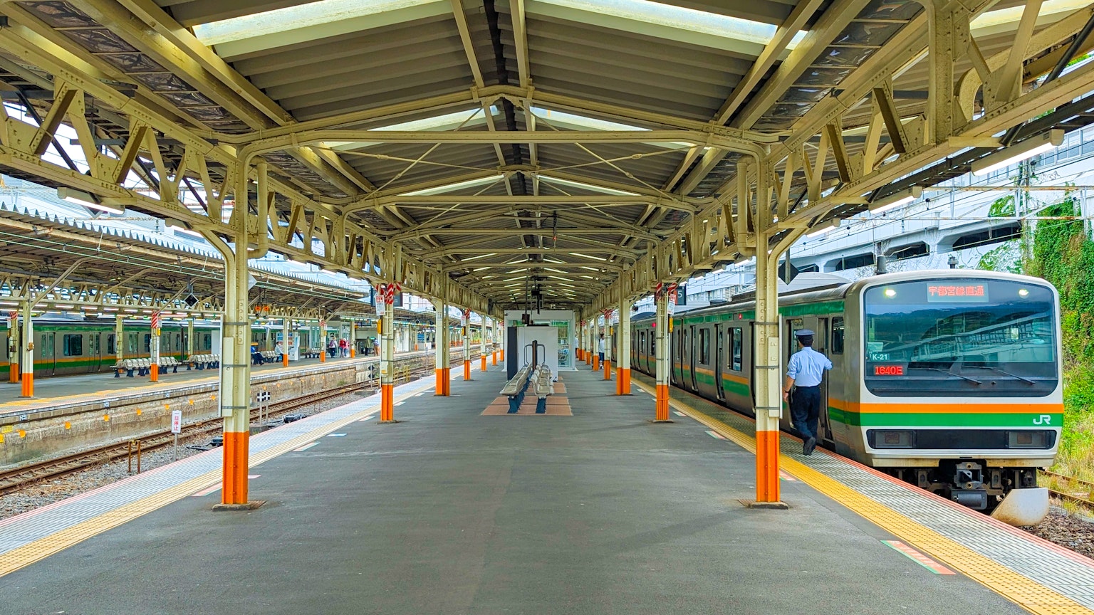 Treno in stazione con passeggeri e dettagli architettonici