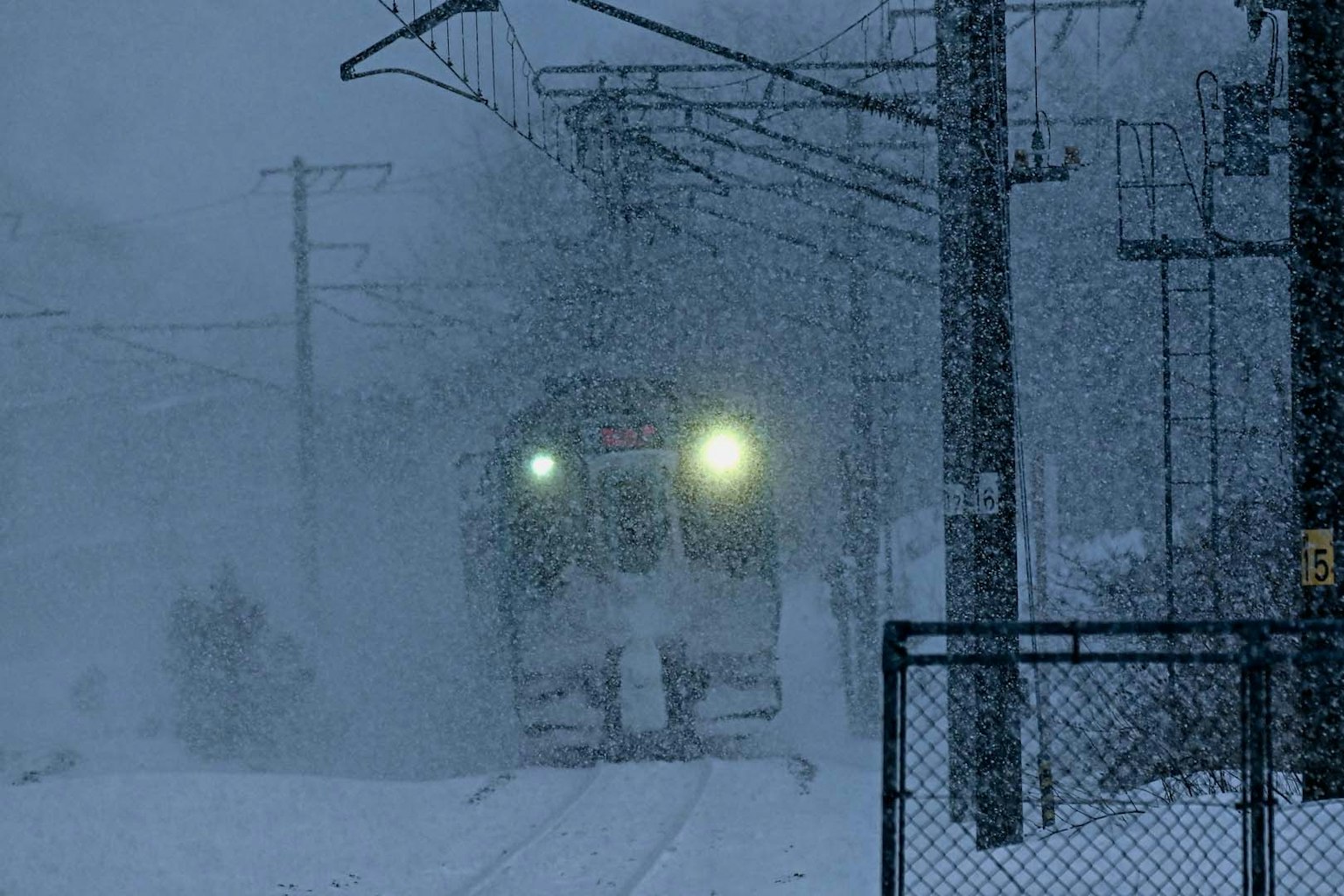 火车车头在大雪中闪烁的灯光和周围的雪景