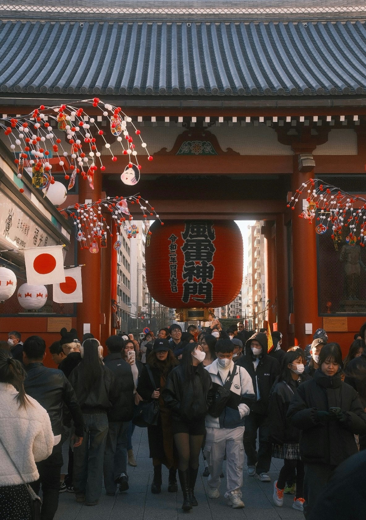 提灯と門前に人が集まる神社の参道