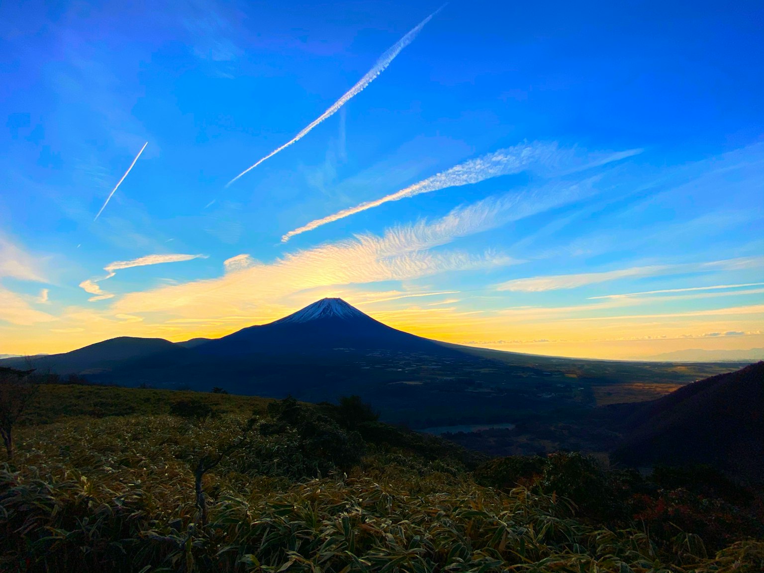 Pemandangan indah gunung berapi di bawah langit biru dengan awan tipis