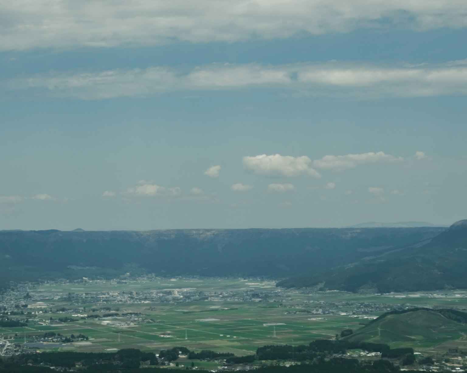 Une vue panoramique de champs verts sous un ciel bleu
