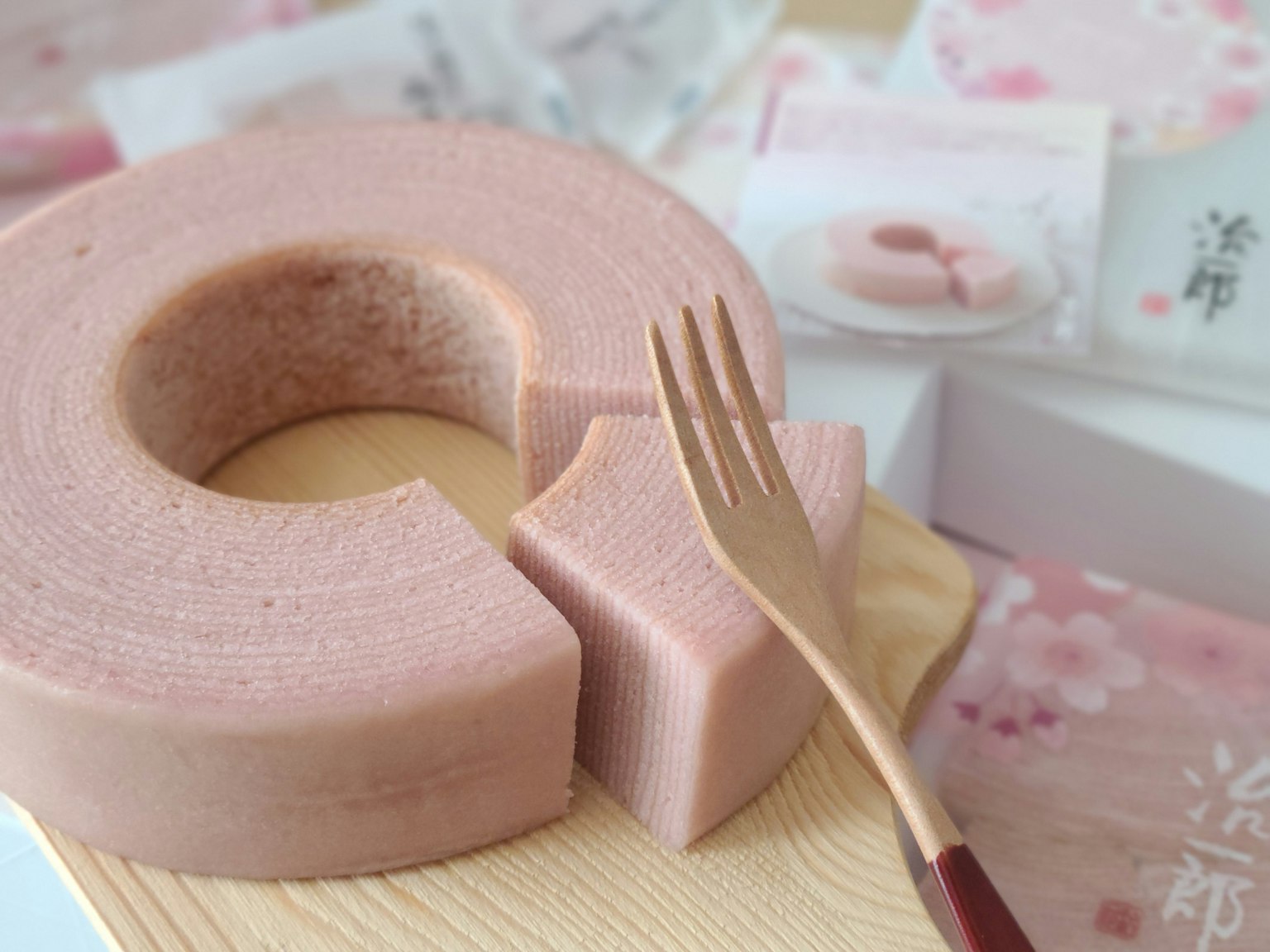 Baumkuchen rosa en un plato de madera con un tenedor al lado