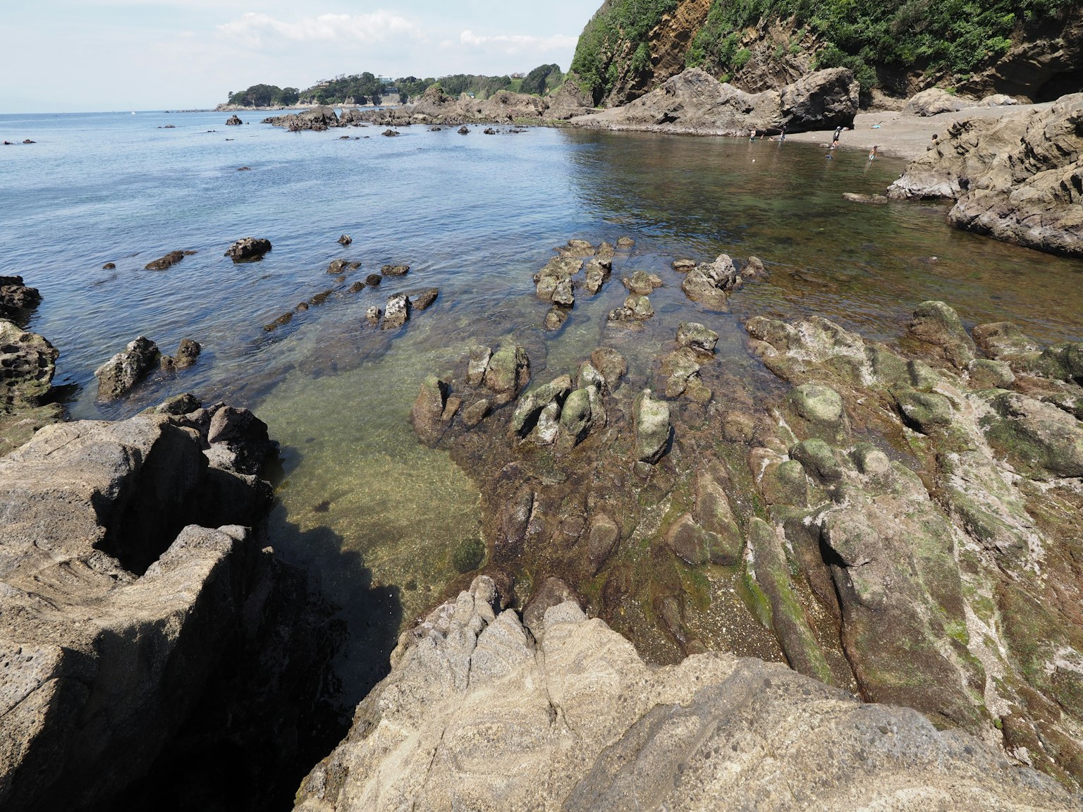 Pemandangan pesisir dengan air jernih dan tepi pantai berbatu