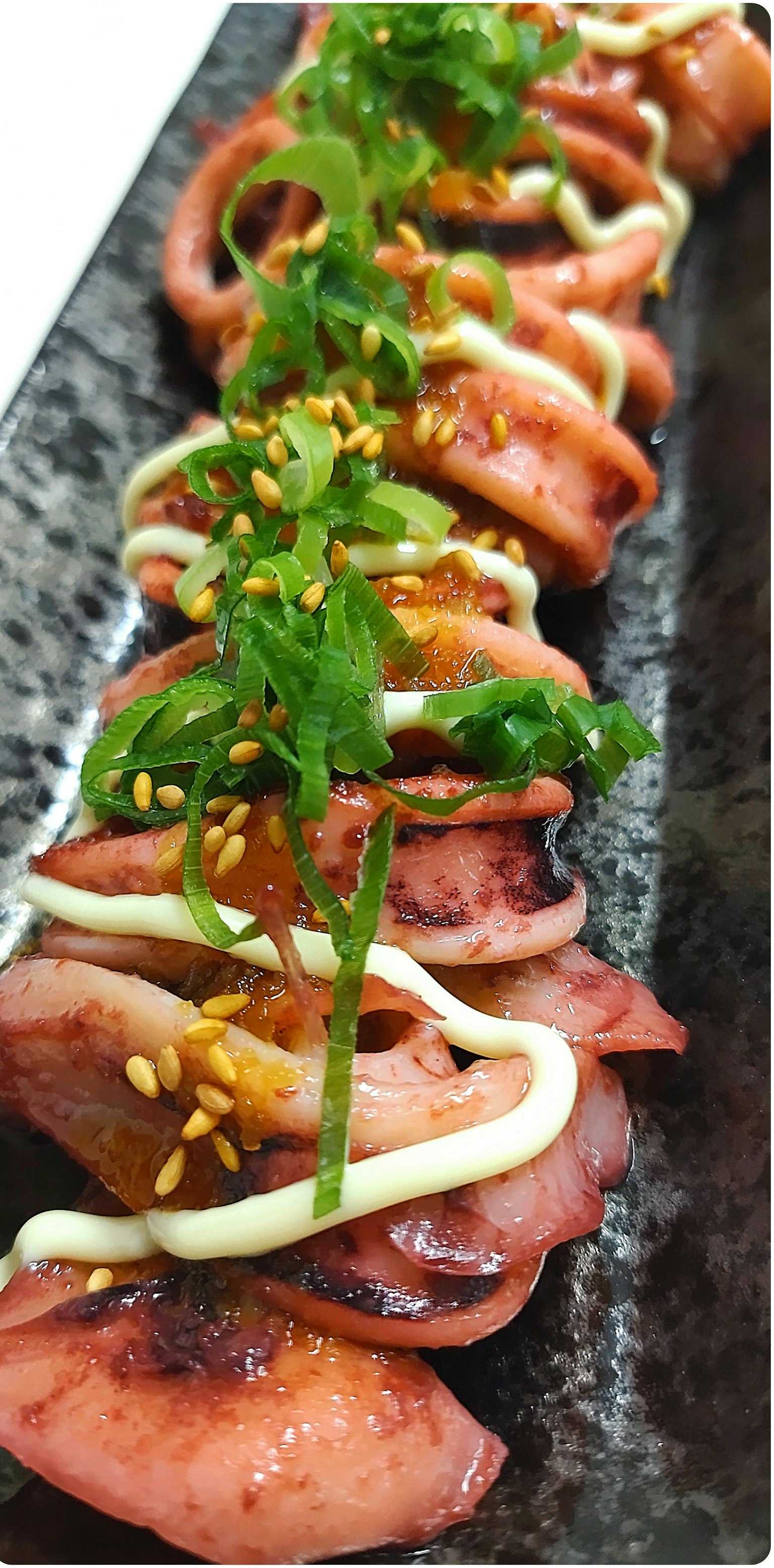 Gegrillte Tintenfischscheiben mit Mayonnaise und Frühlingszwiebeln