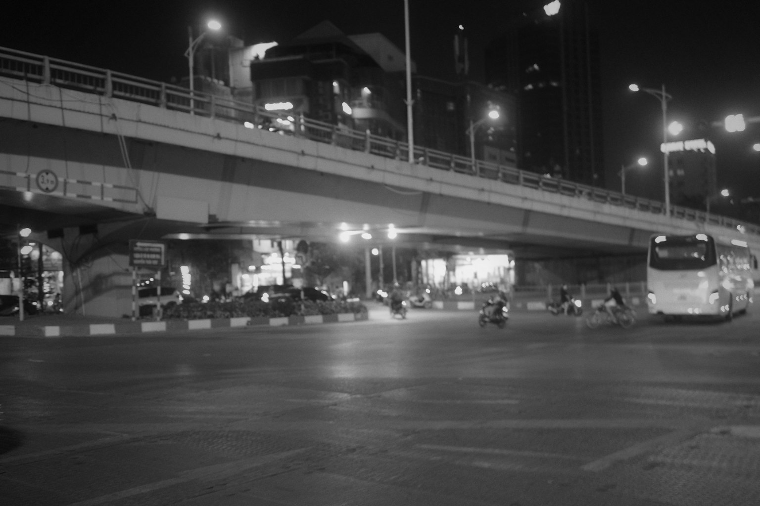 Scena notturna di città con traffico e sovrappasso