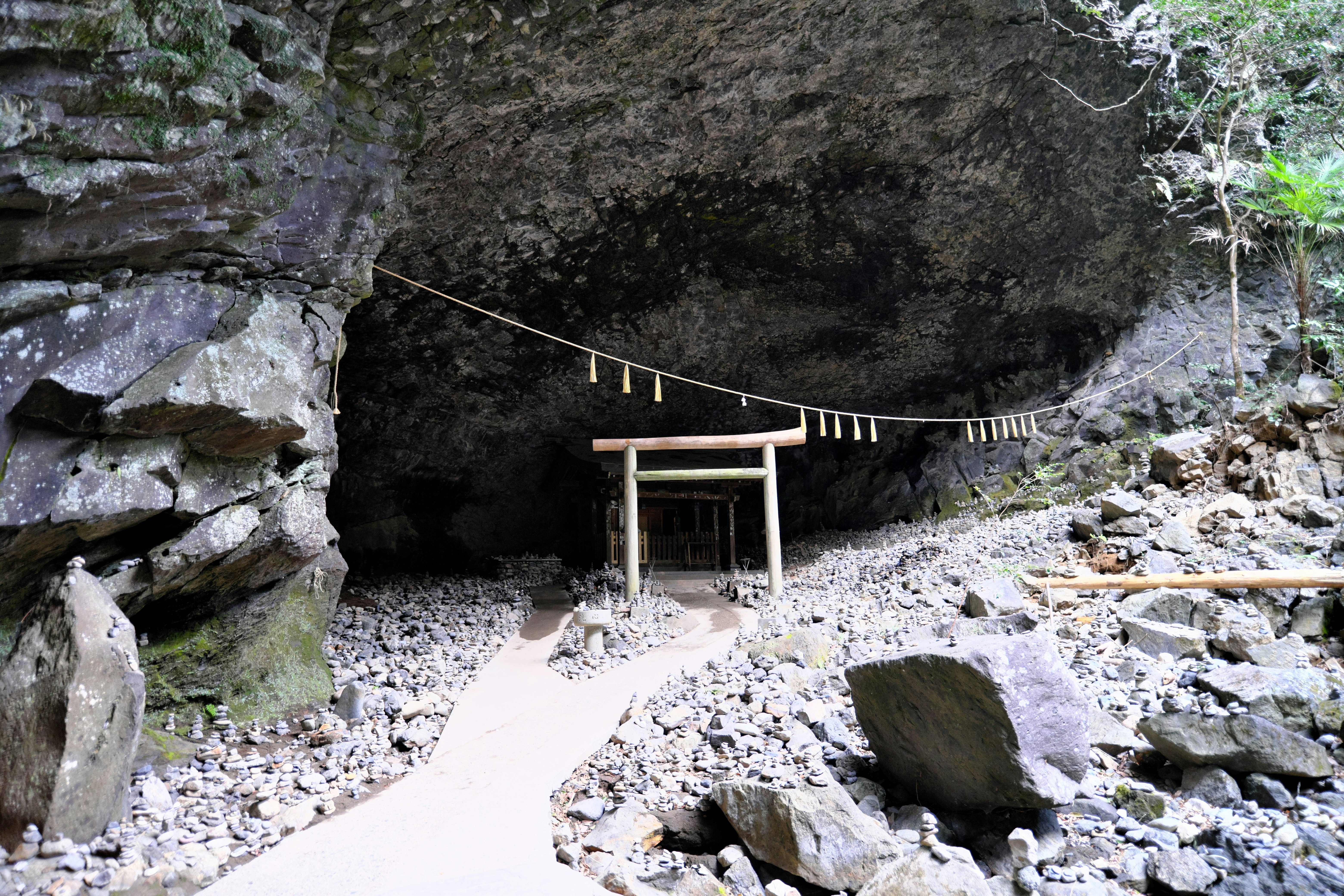 Cổng torii với shimenawa trước hang đá