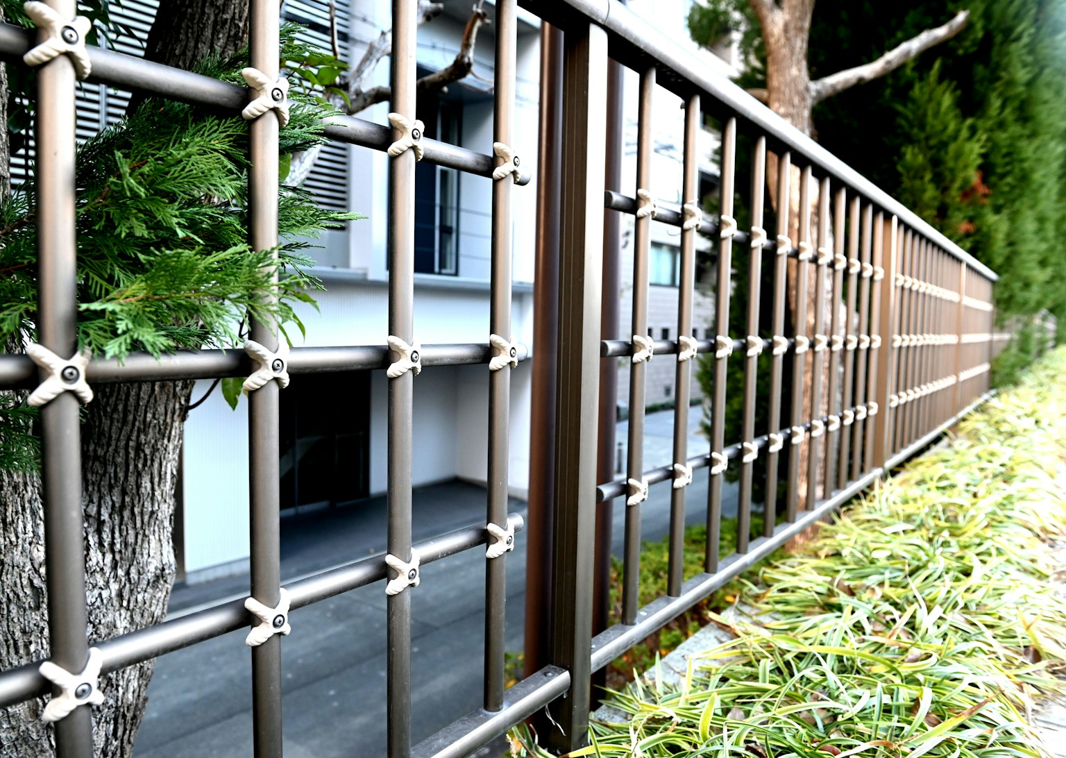 Modern metal fence with greenery in the background
