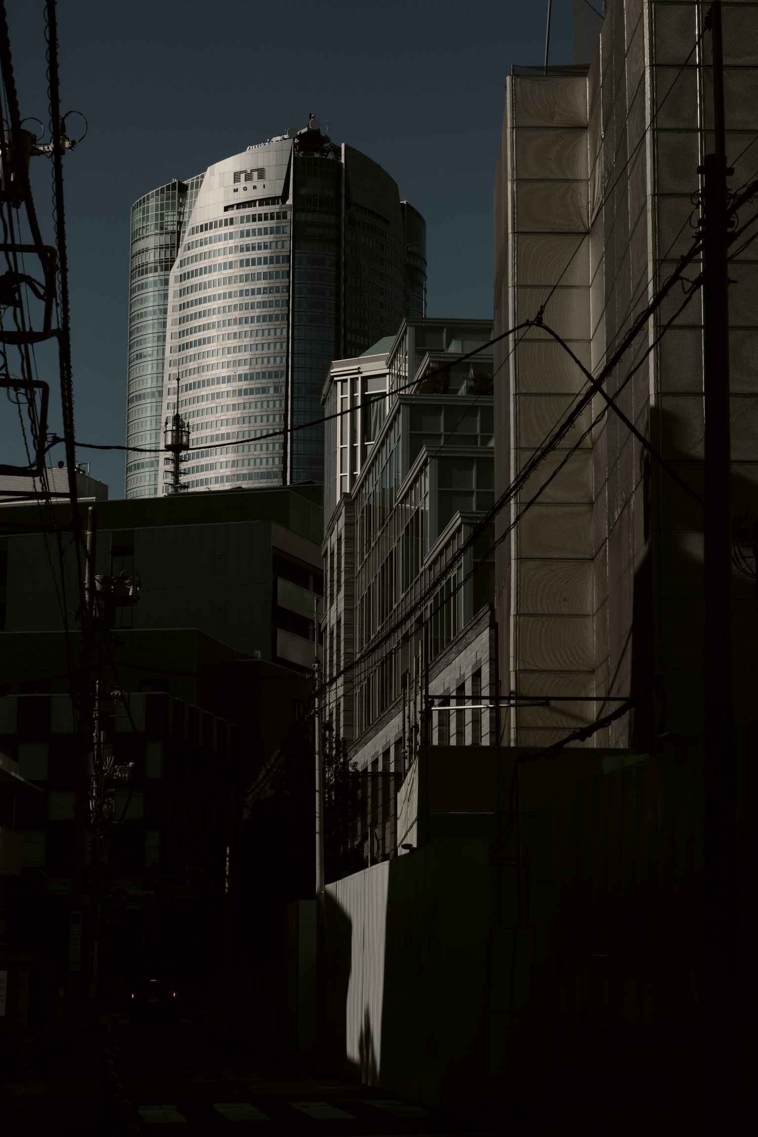 Siluet gedung pencakar langit di belakang gedung perkotaan di Tokyo