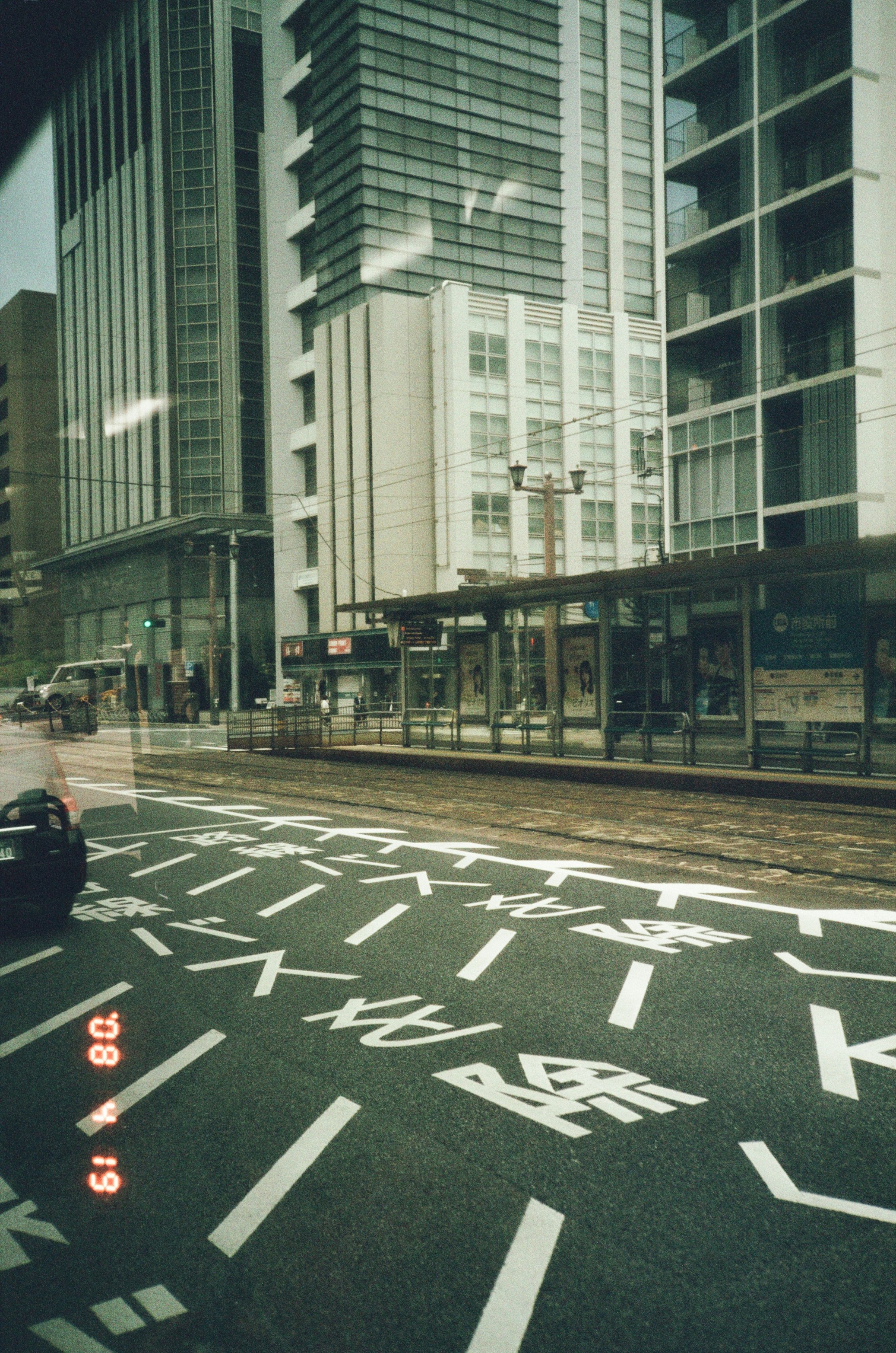 高層ビル街の交差点で横断歩道の白線が見える風景