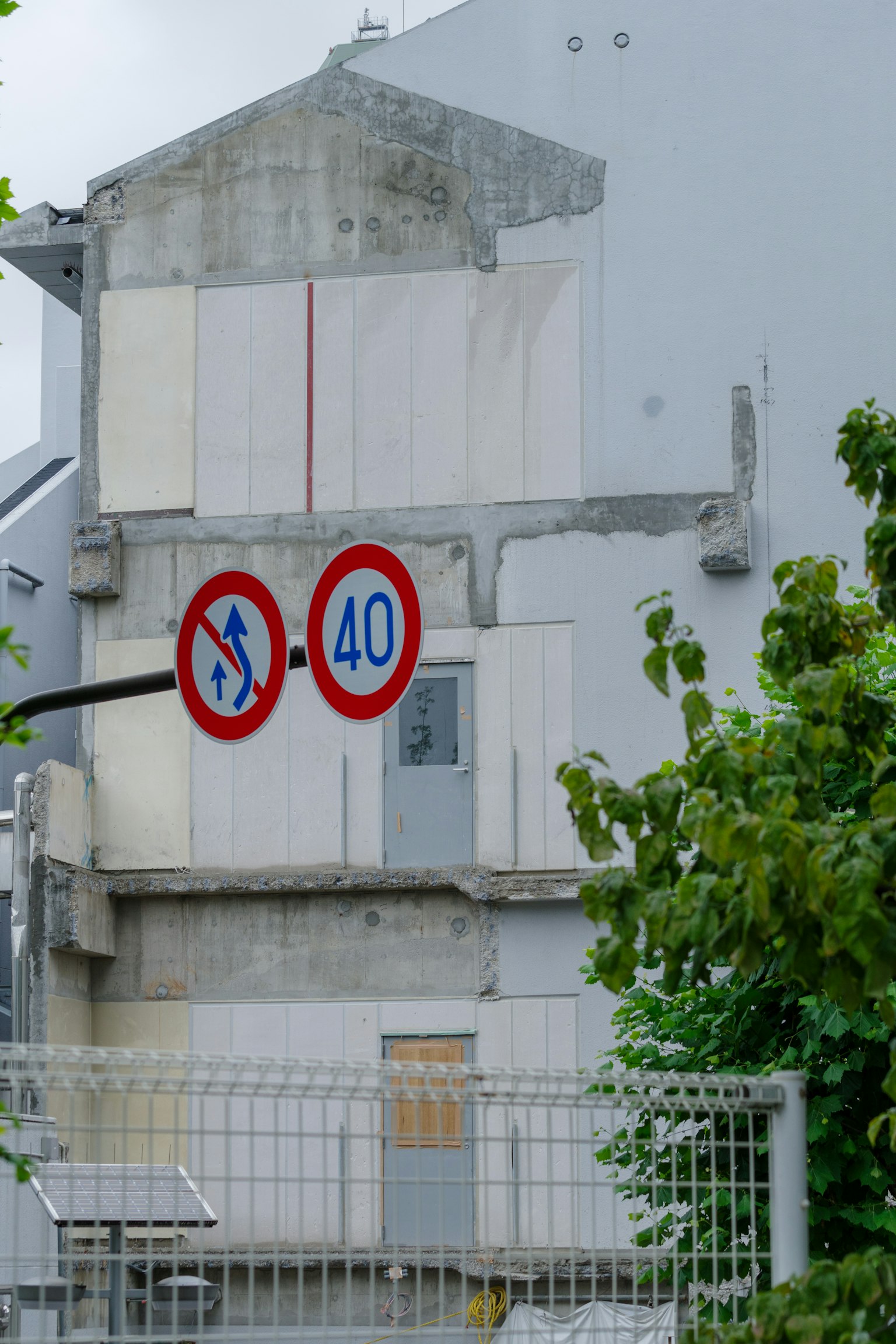 Côté d'un bâtiment avec des murs blancs présentant des panneaux de circulation