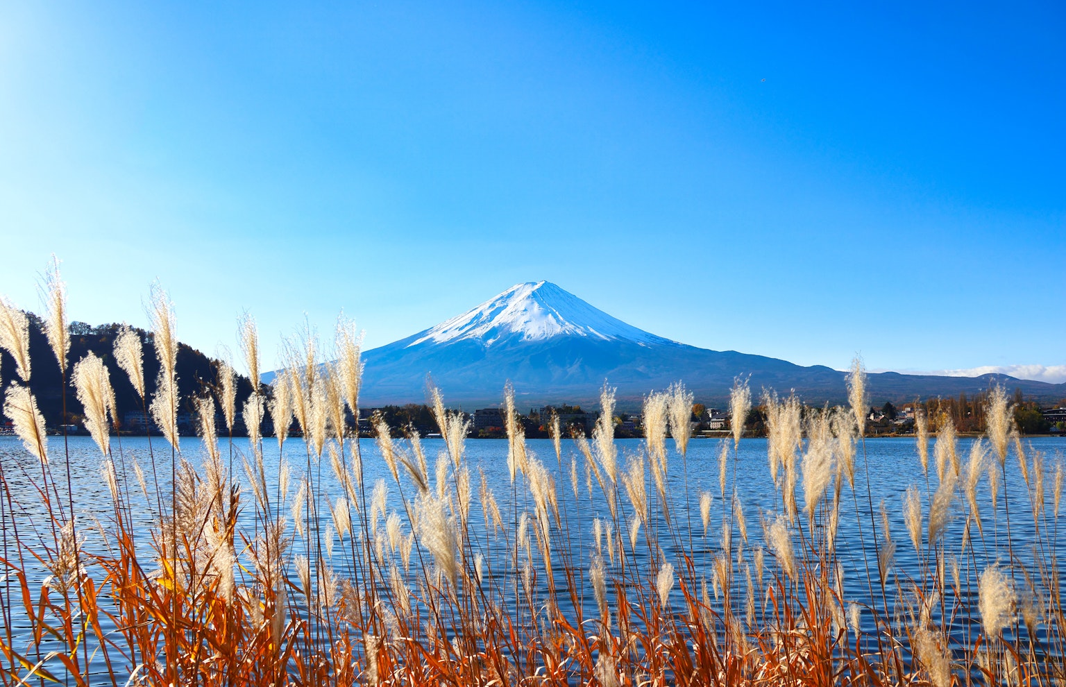 Scenic view of Mount Fuji with a lake, blue sky and snow-capped peak