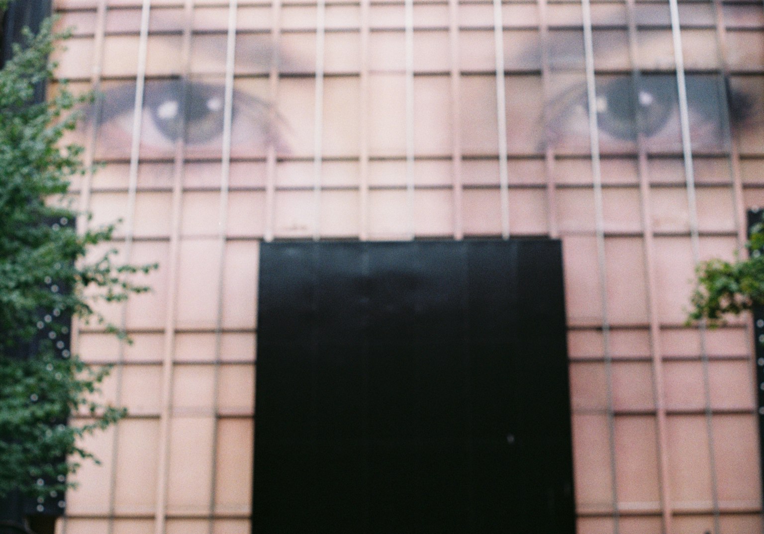 大きな目のアートが描かれた建物の外観と黒い部分