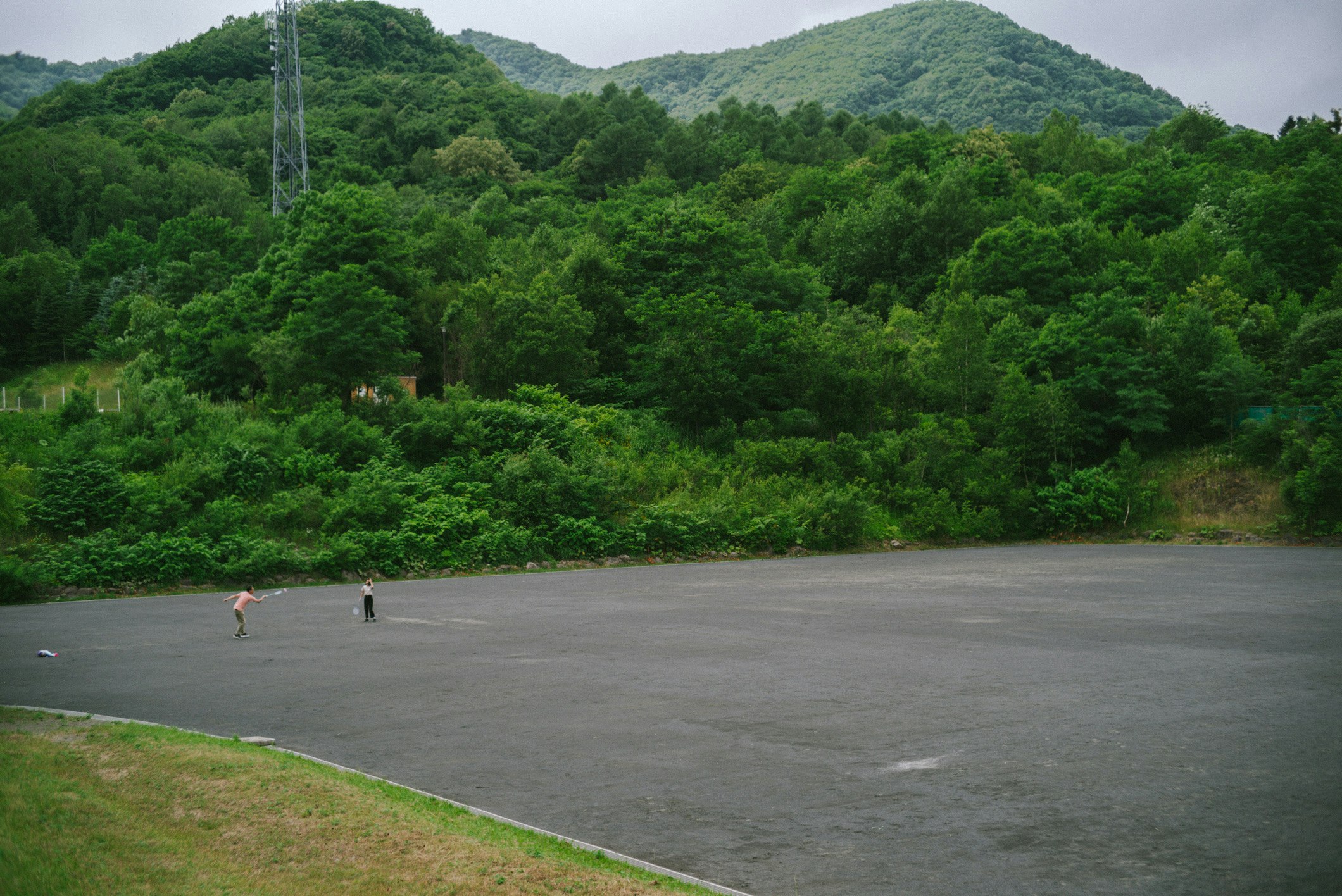 緑の山に囲まれた広い川辺の河川敷