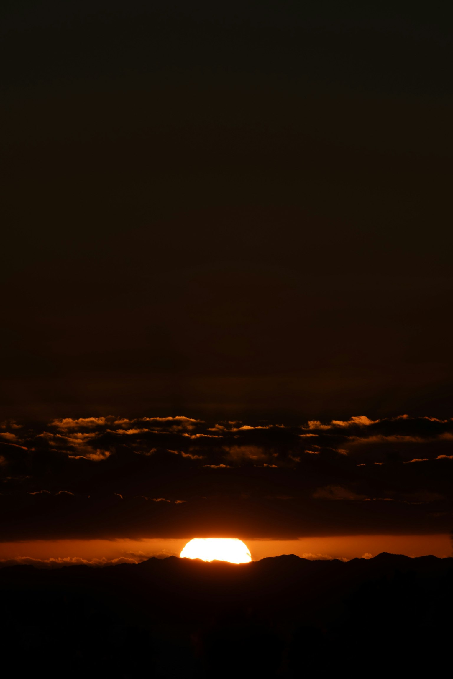 Hermoso atardecer saliendo entre montañas