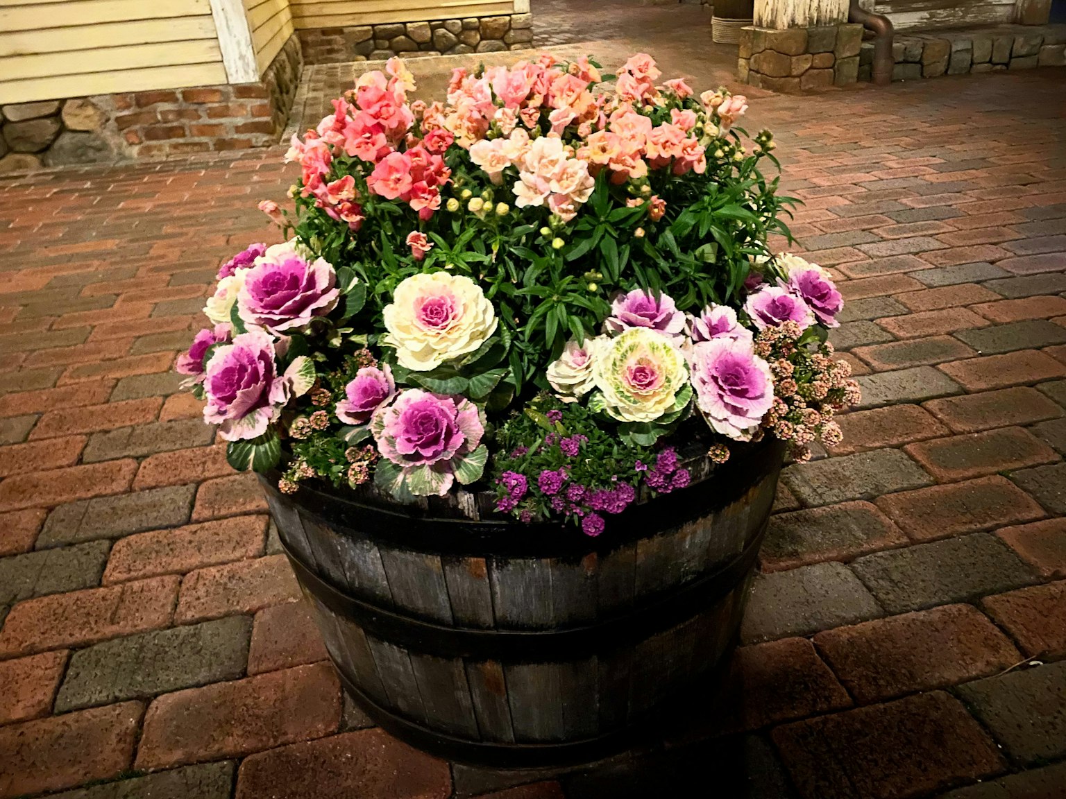 Un barile di legno pieno di fiori colorati in fiore