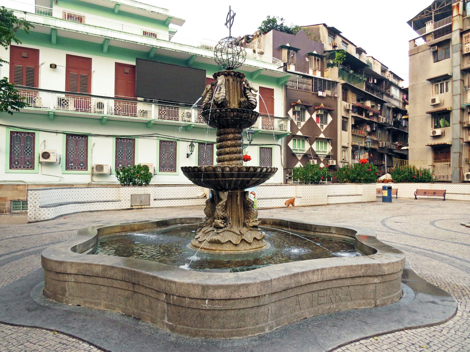 Fontaine décorative dans une place publique entourée de bâtiments
