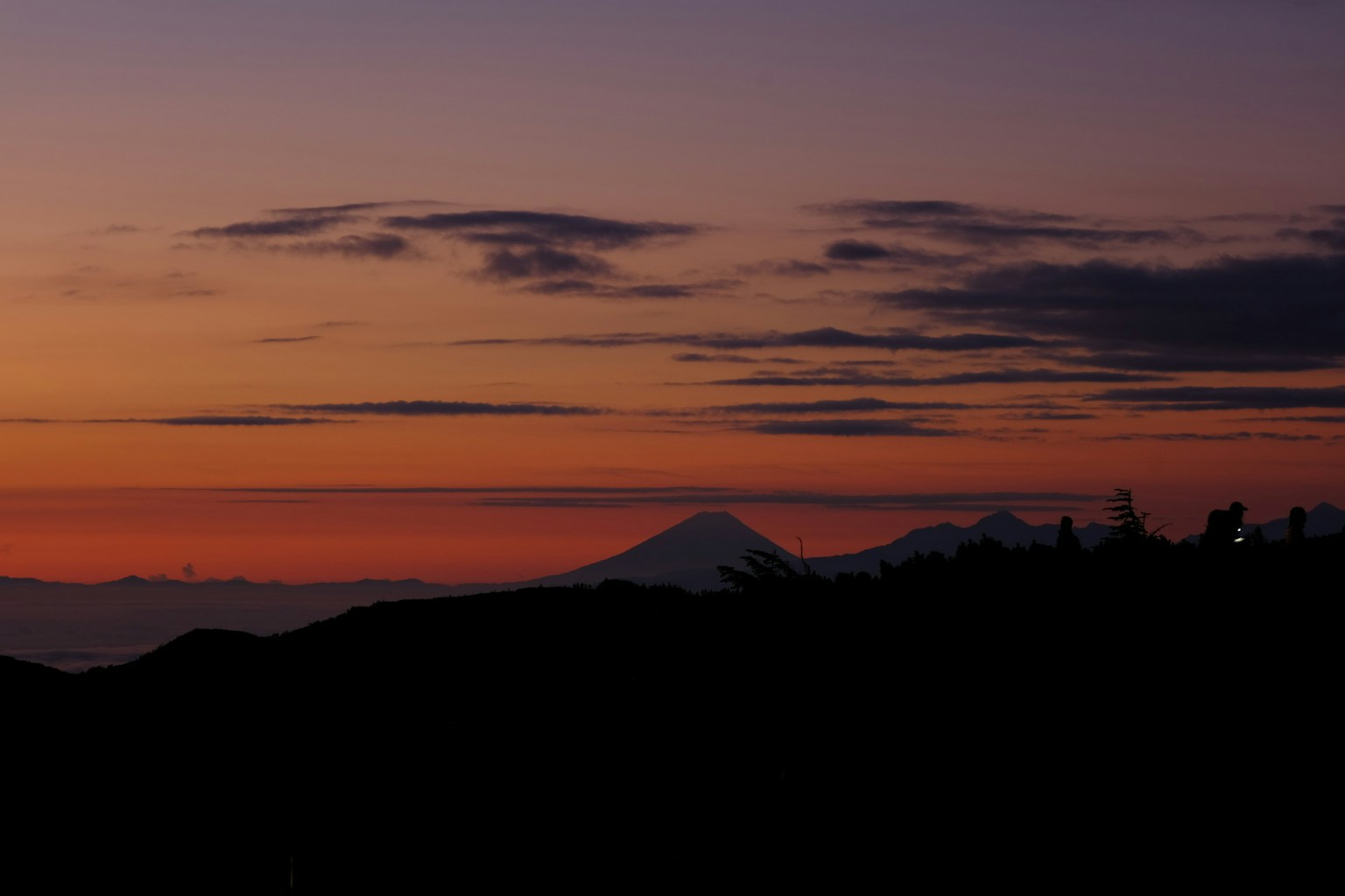 Silhouette of mountains against a sunset sky with vibrant colors