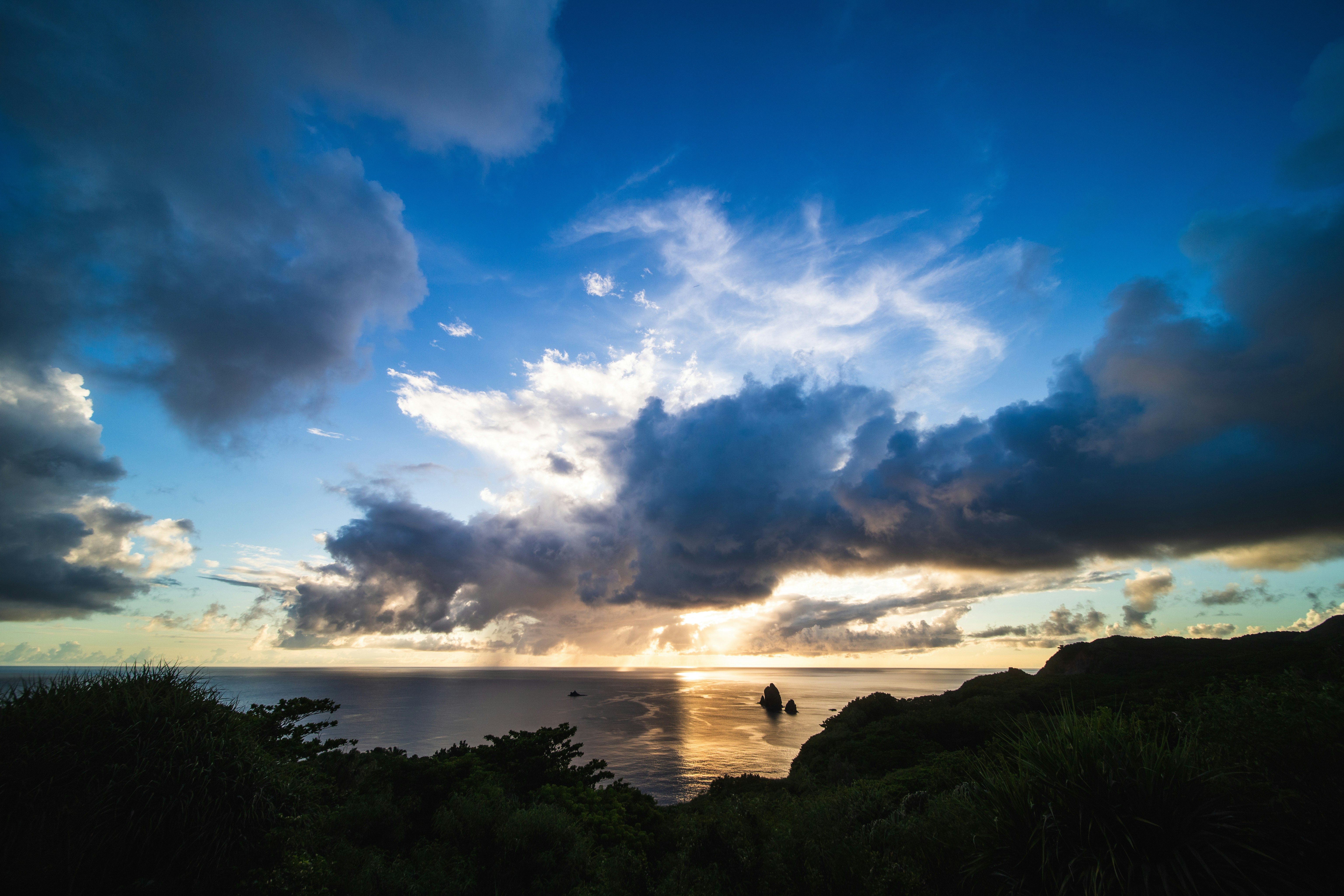 從自然山坡俯瞰的海灣與海面日落