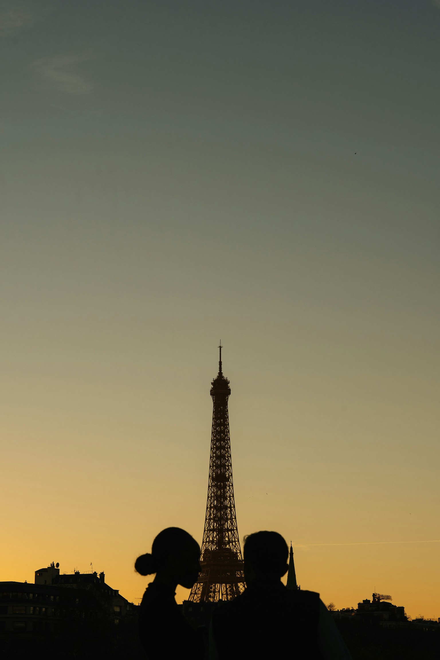 夕暮れ時のエッフェル塔を背景にしたカップルのシルエット
