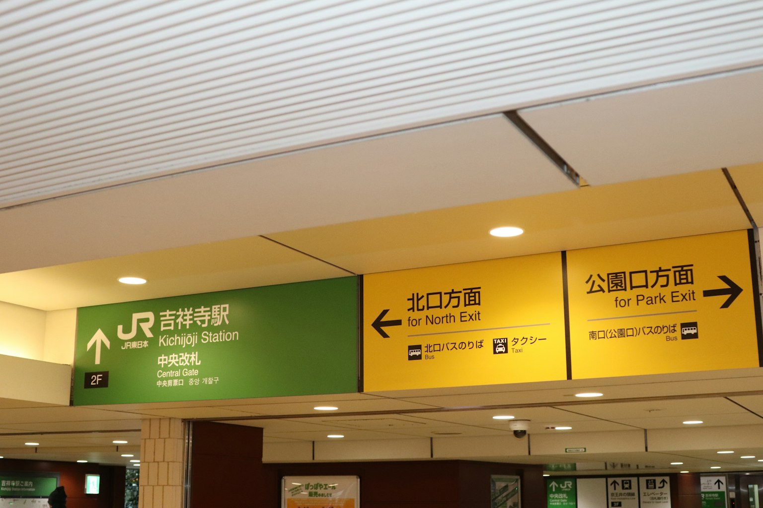 Tanda di Stasiun JR Shinjuku dengan indikator arah berwarna hijau dan kuning
