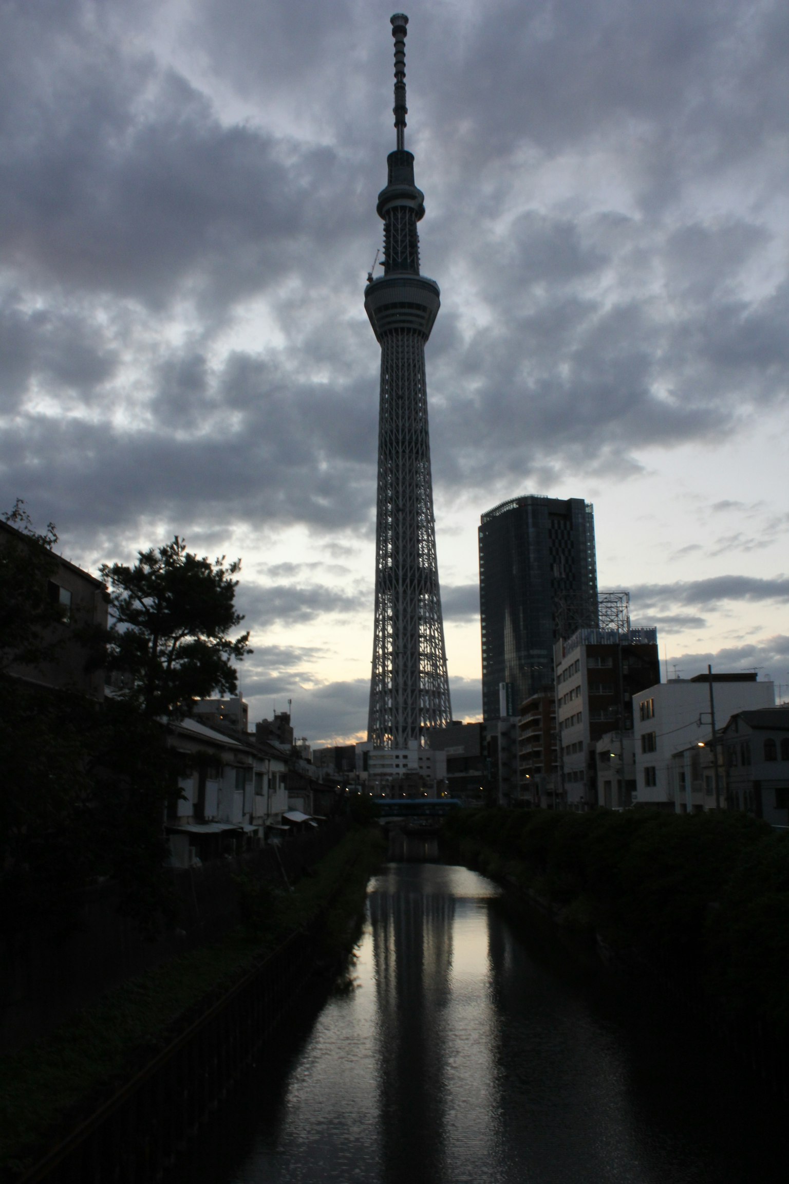 Tokyo Skytree silhouettiert gegen einen Dämmerungshimmel mit Reflexion im Fluss